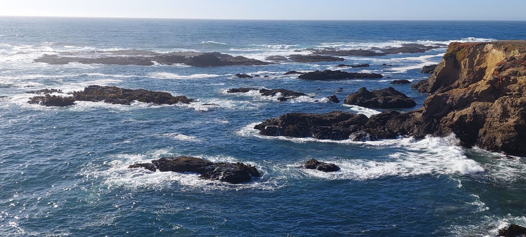 Sunny ocean view with many dark rocks and white crashing waves. - Noyo Headlands – Fort Bragg loop from Fort Bragg