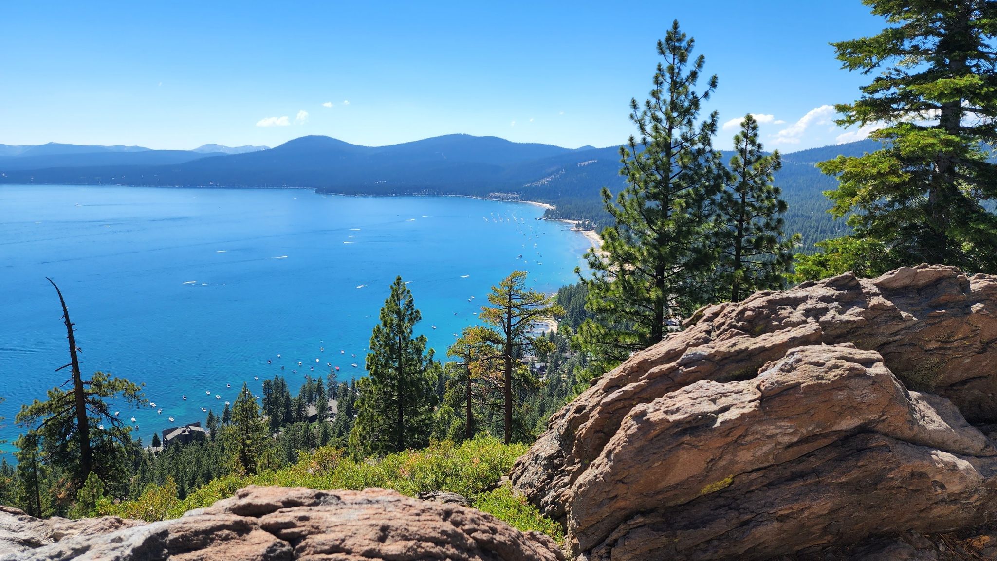 Panoramic view of a bright blue lake, mountains, and pine trees. - Incline Village to Crystal Bay & Fire Lookout loop