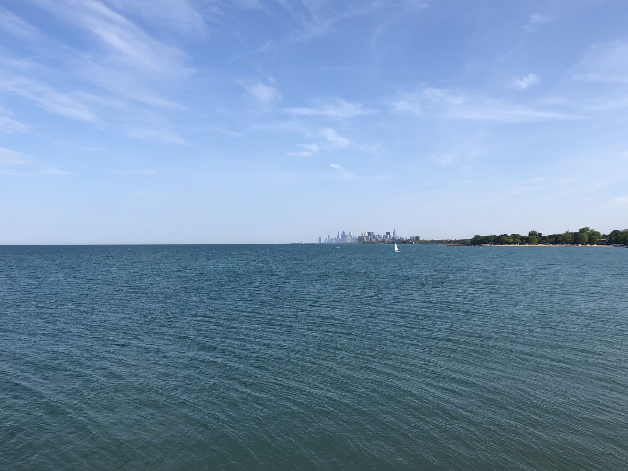 Expansive calm water with a distant city skyline and a small sailboat. - Grosse Point Lighthouse – Green Bay Trail loop from Lake Forest