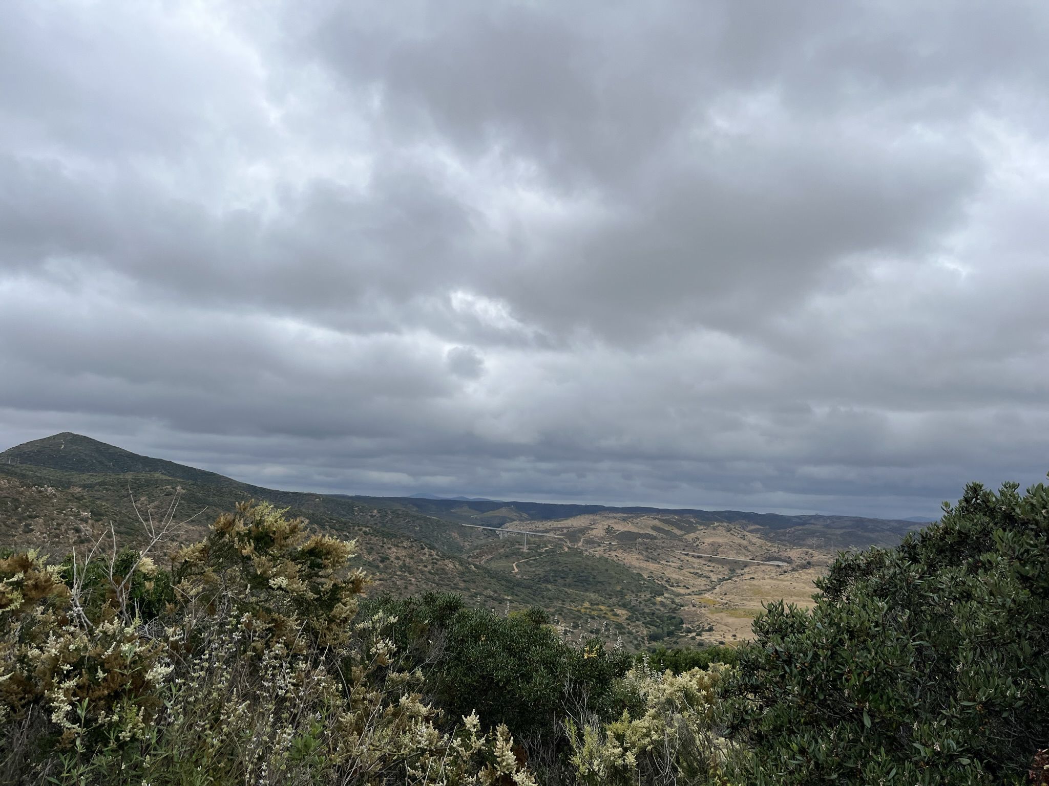 Overcast sky above a vast valley with rolling hills and green foliage. - Kwaay Paay Peak Trail – Kwaay Paay Peak loop from Mission Gorge Rd & West Hills Pkwy