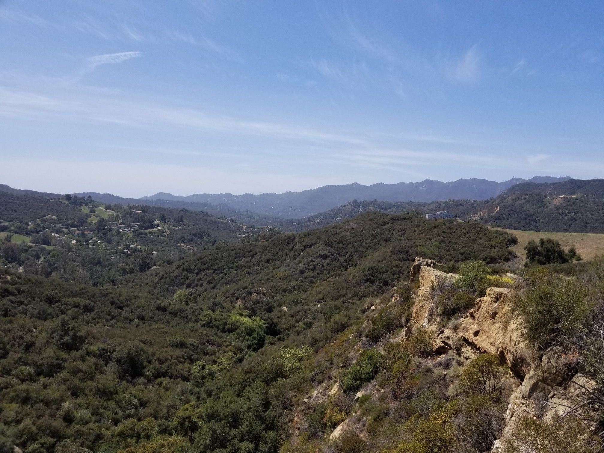 Expansive view of lush green valleys and distant mountains under a clear blue sky. - Santa Maria Creek Trail