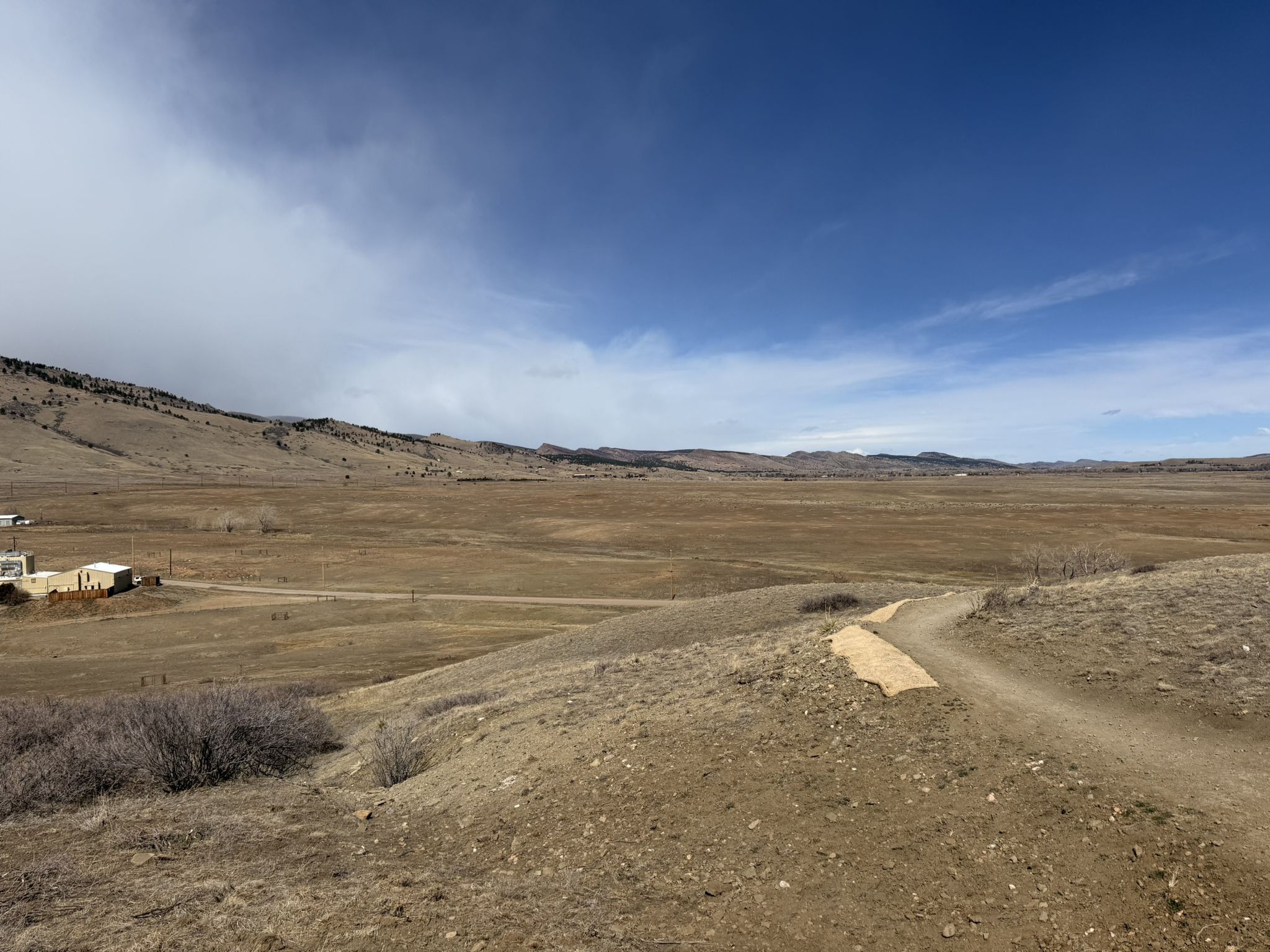 Wide view of a dry, rolling landscape with a dirt path and distant hills. - Mesa Reservoir loop from Dakota Boulevard Parking