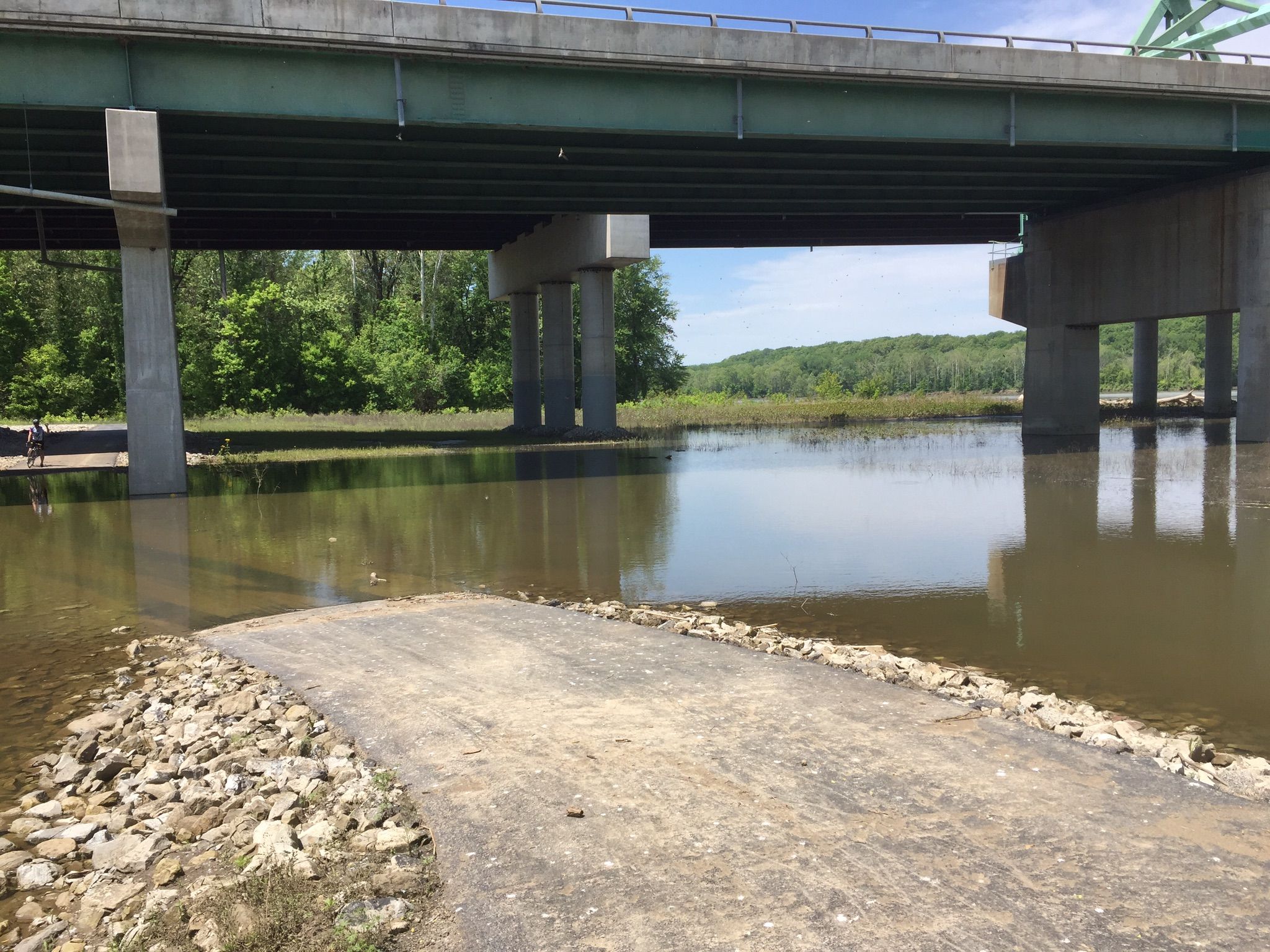Flooded ground and a paved ramp under a large concrete bridge. - Le Cave Memorial Trailhead – Edison Avenue loop from Ellisville