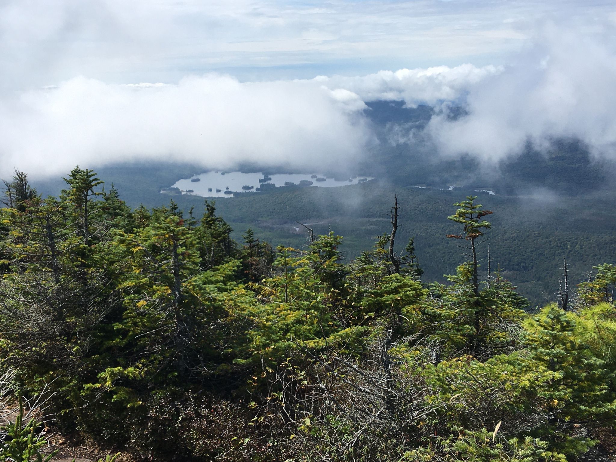 Overcast view of a lake surrounded by forest and low-hanging clouds. - Hough Peak via Hunters Pass, Lillian Brook, and Beckhorn Trail Loop