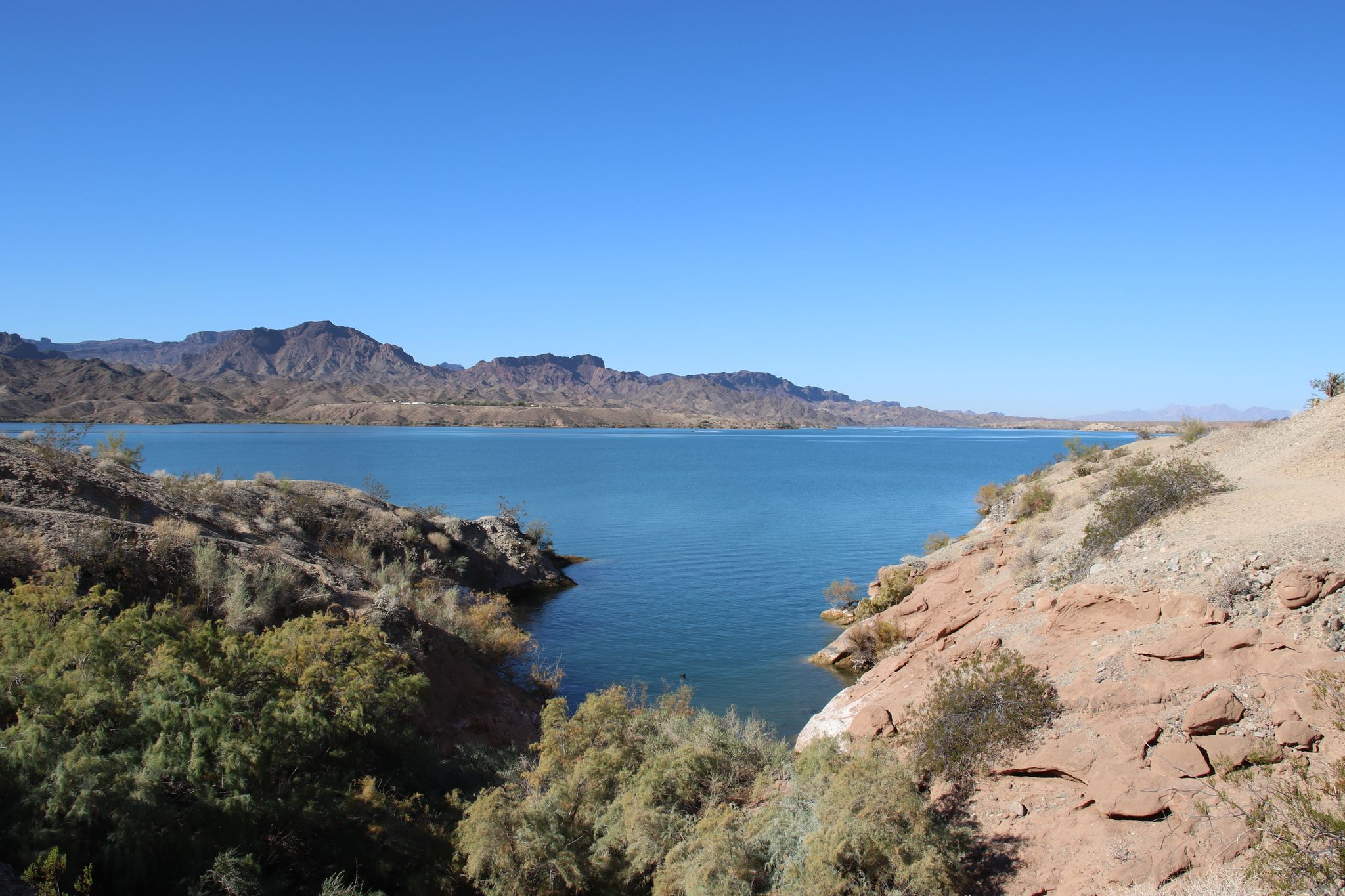 Expansive blue lake framed by arid mountains and rocky, brushy shores on a clear day. - Ripley's Run