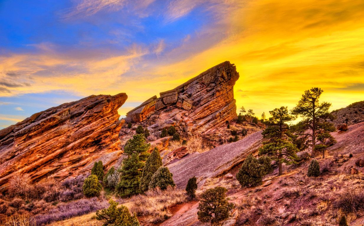 Dramatic sunset over large red rock formations and scattered trees. - Evergreen to Genesee loop from Golden