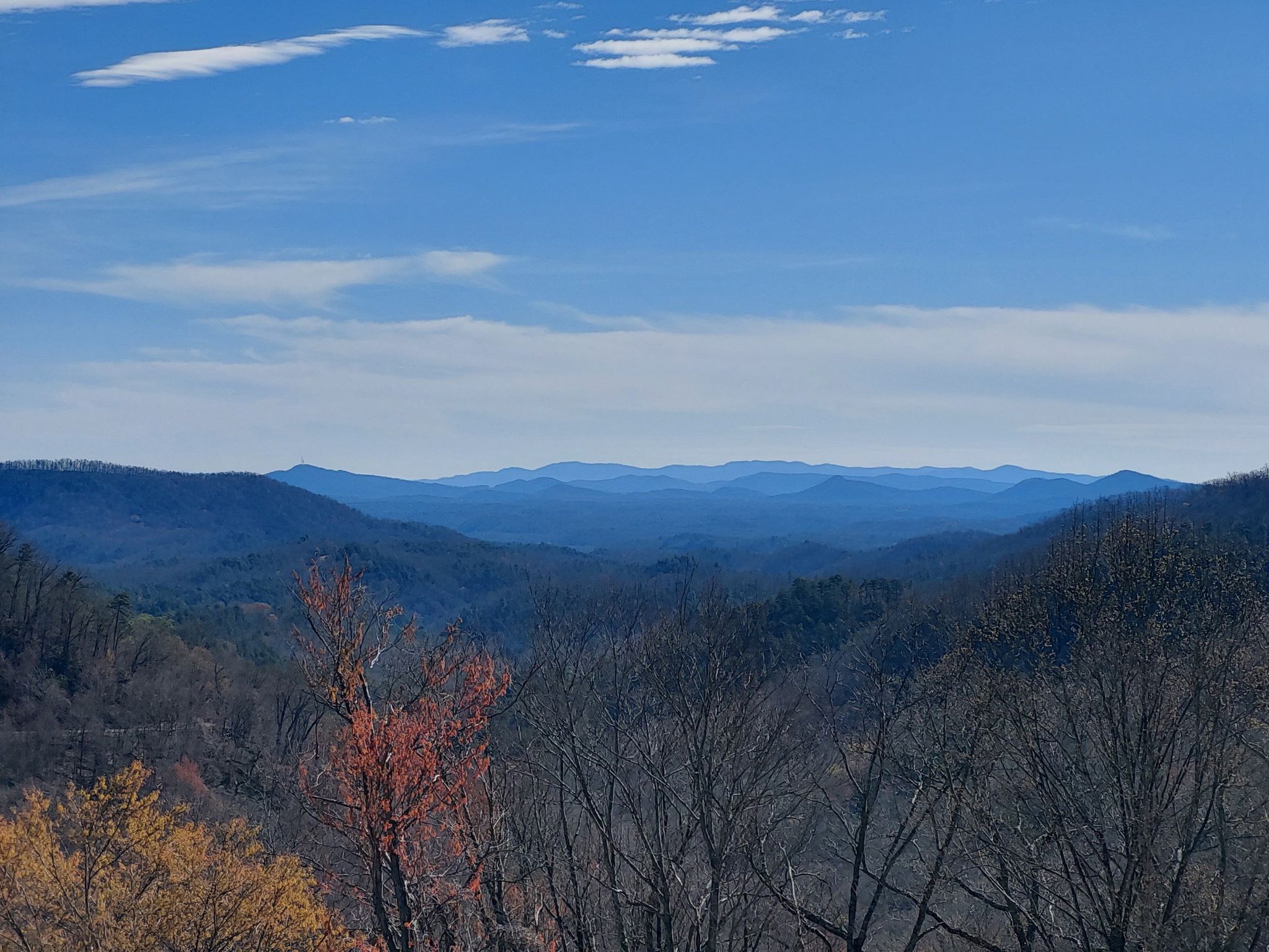 Expansive view of layered blue mountains and valleys under a bright sky. - Point Lookout loop from Old Fort