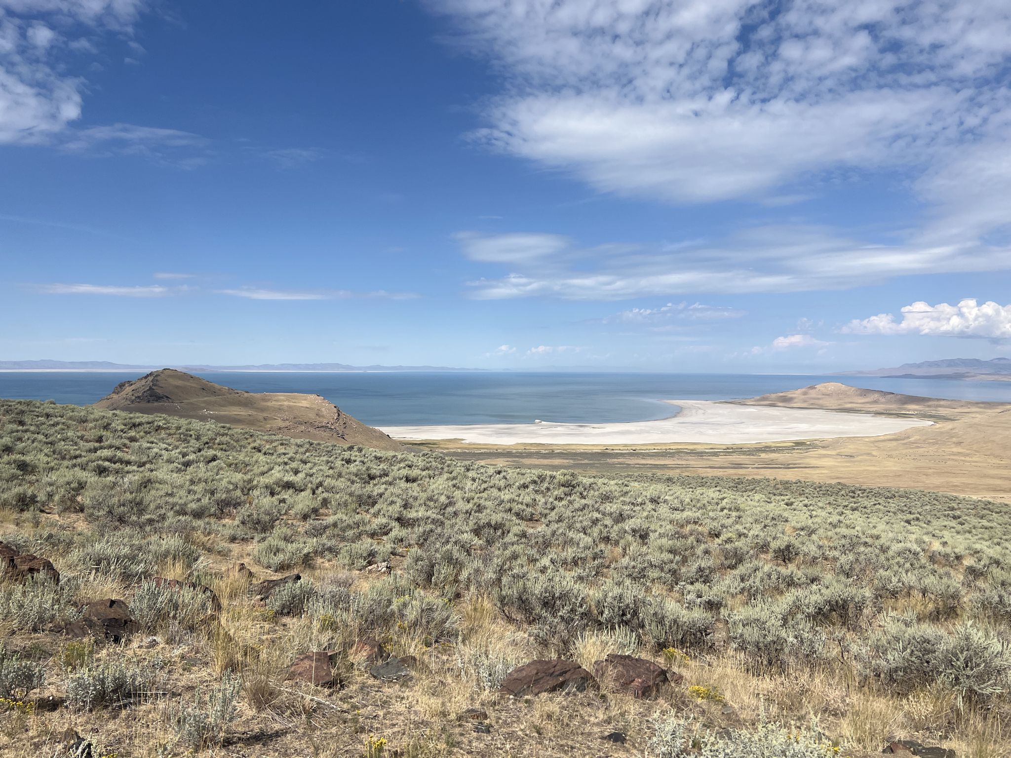Expansive view of a large lake, hills, and scrubland under a partly cloudy sky. - Frary Peak Trail