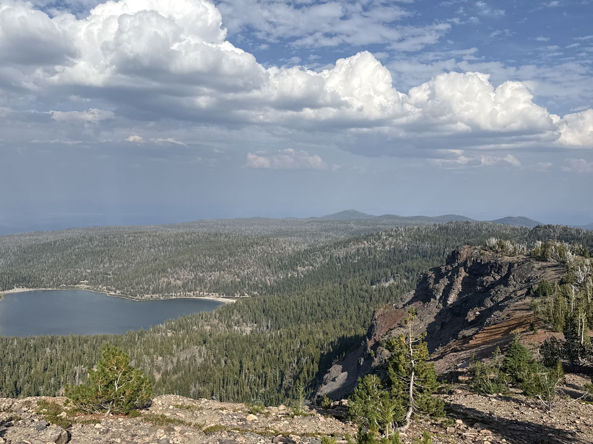 Overcast sky above a large lake surrounded by dense forest and cliffs. - Tam McArthur Rim Trail to Broken Hand