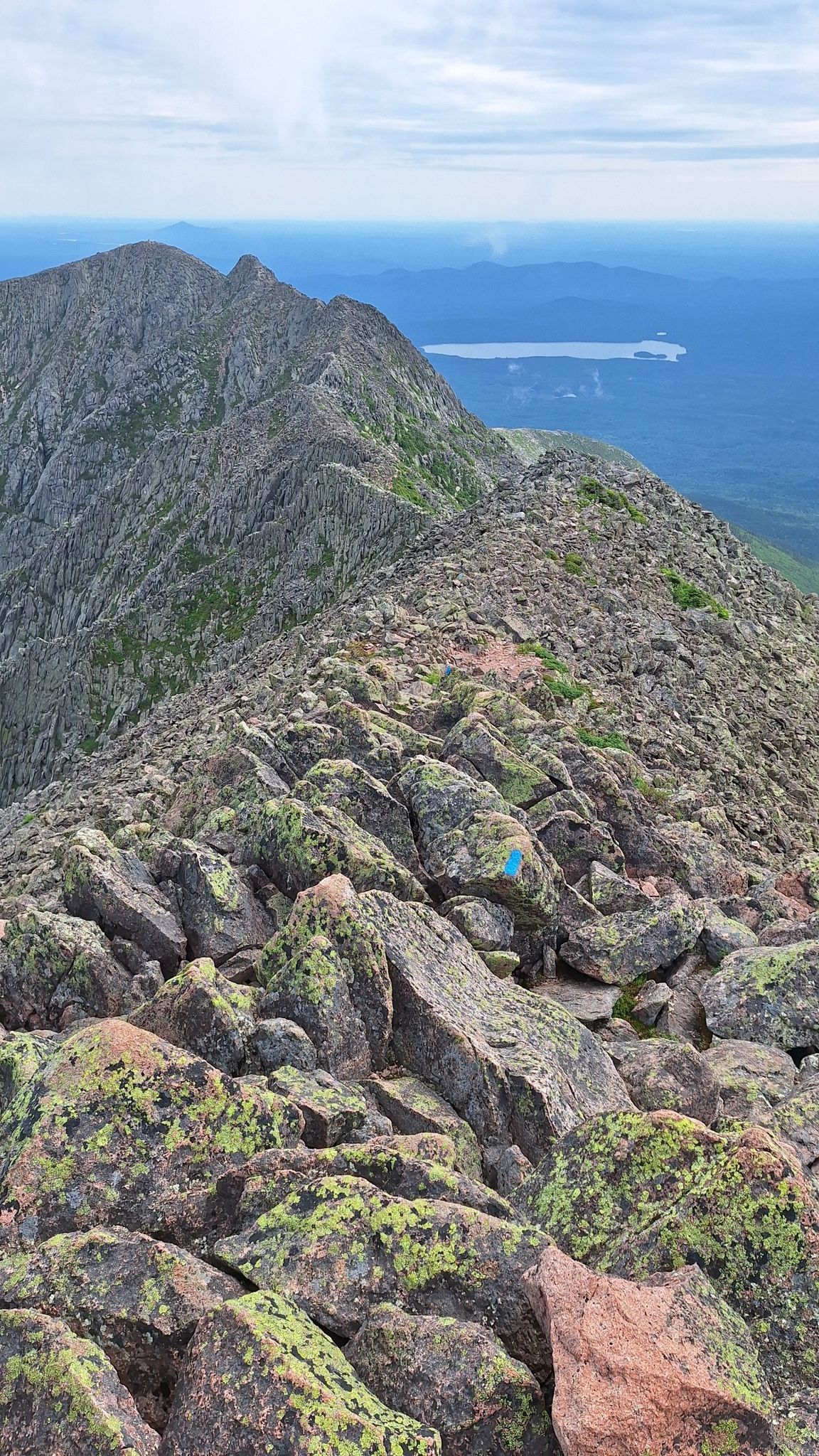 Rugged mountain ridge with a rocky path and distant lake. - Katahdin & Knife Edge loop