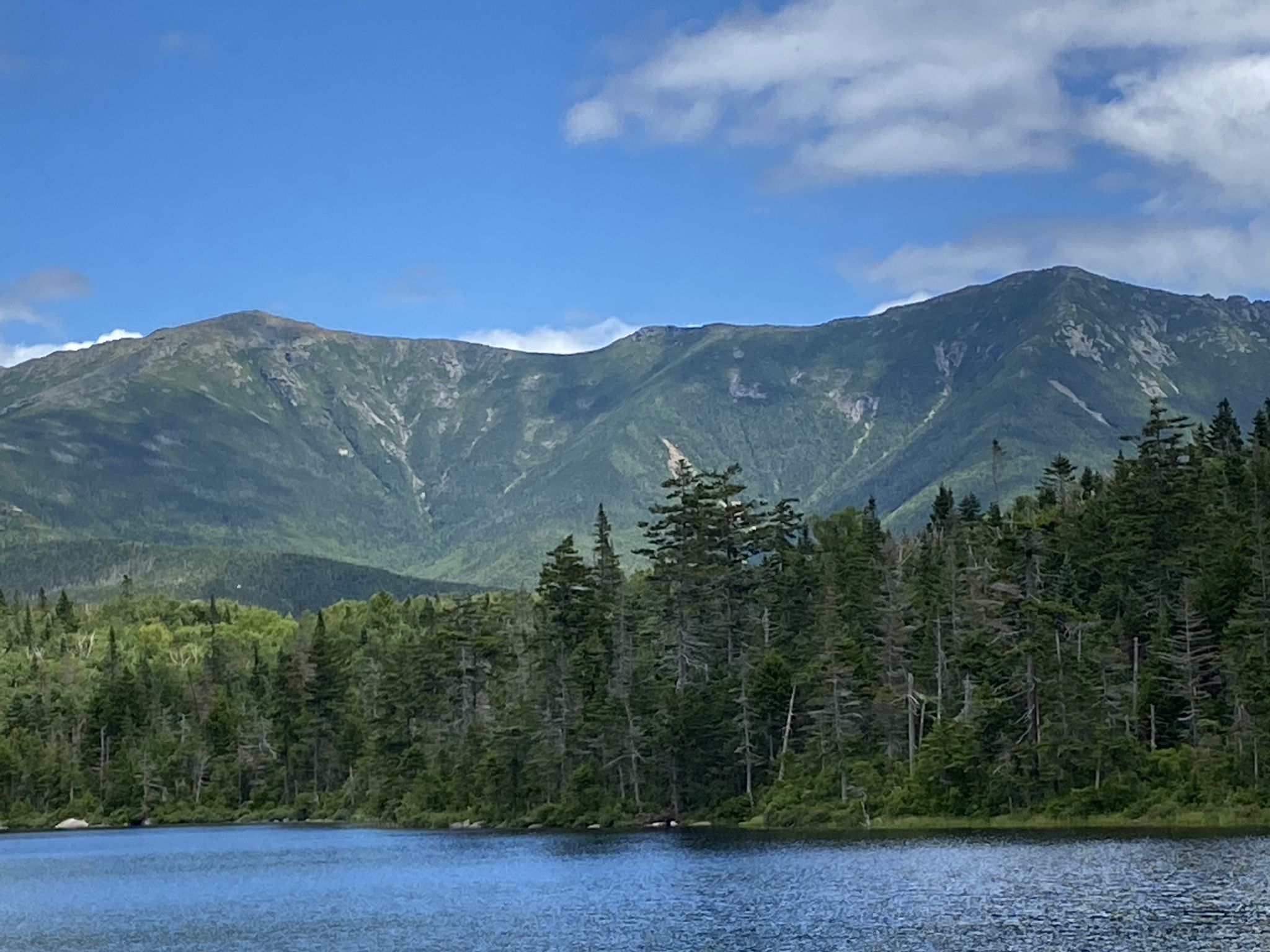 Large lake with a dense forest on the shore and towering mountains in the background. - North Kinsman, South Peak and Cannon Balls Loop Trail