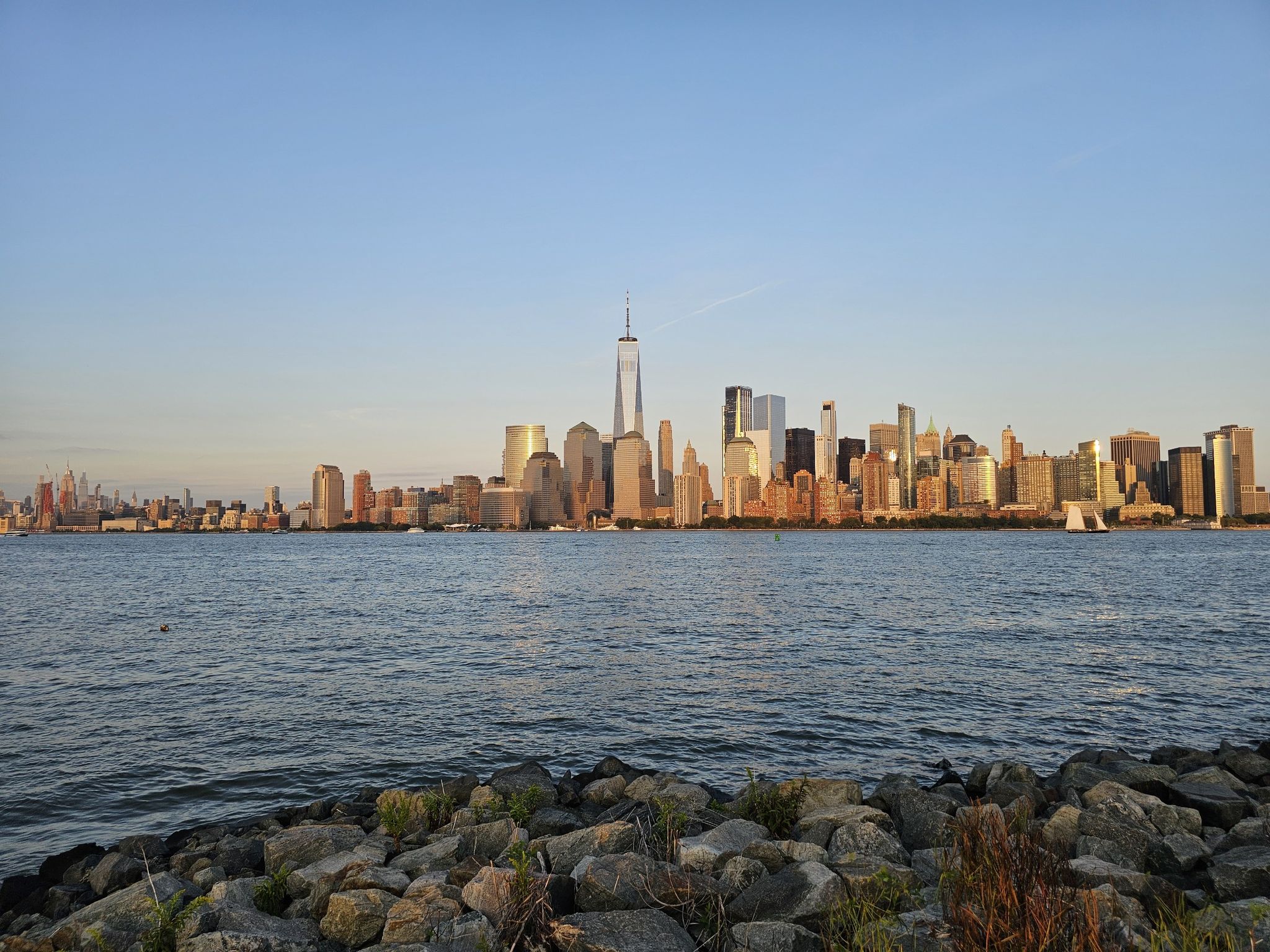 City skyline across water at sunset, with golden light on buildings. - Goethals Bridge – Warinanco Park loop from Cranford