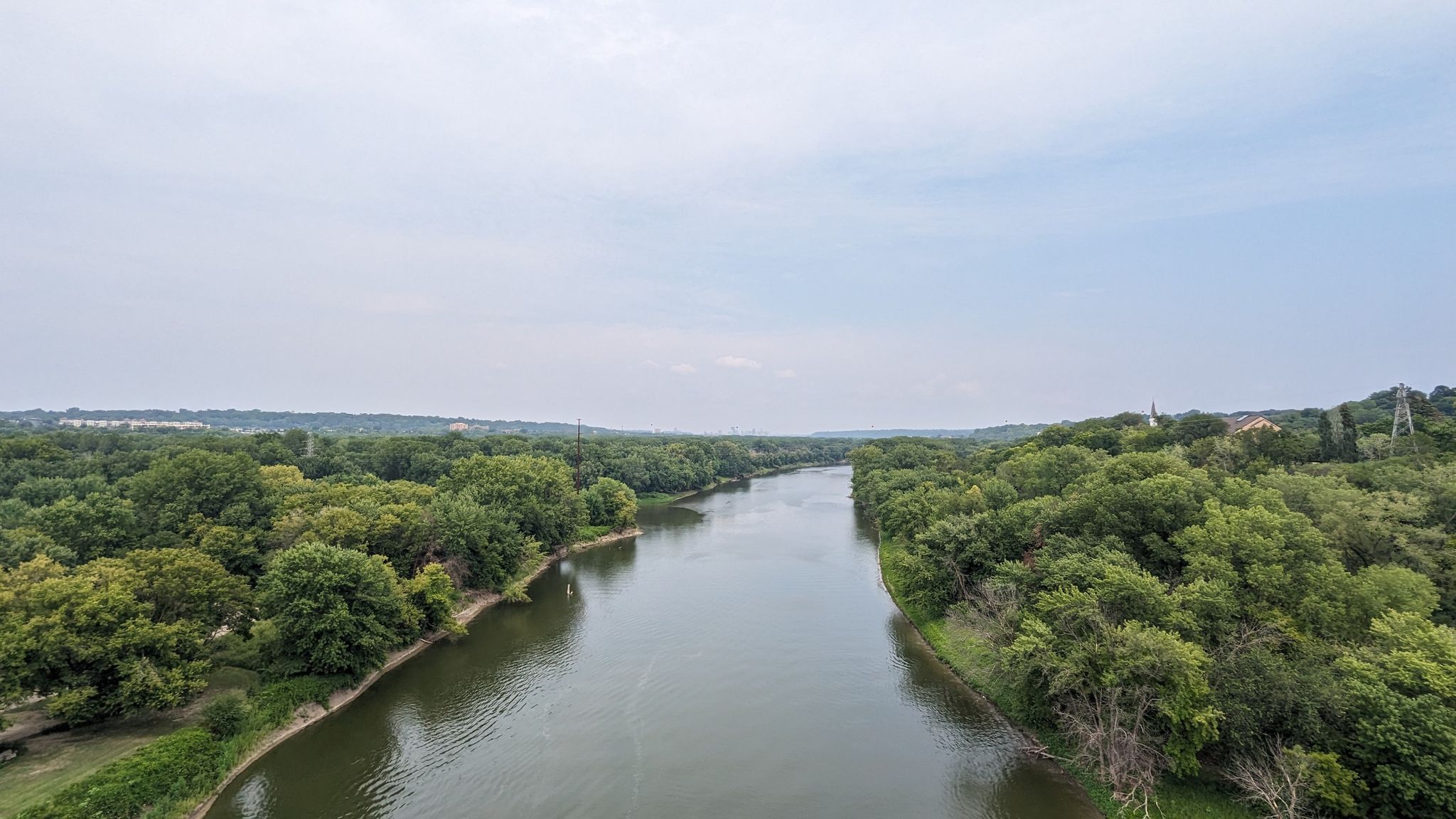 River winding through dense green forests under a bright, cloudy sky. - Minnesota River and Big Rivers Trail Loop