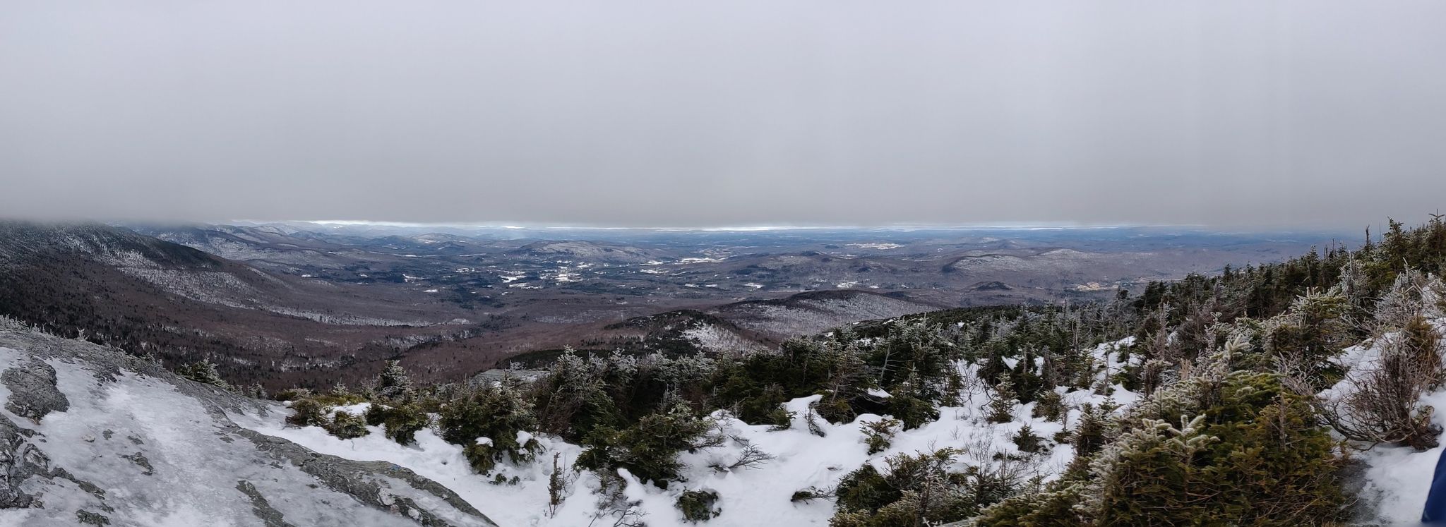 Panoramic view of a snow-covered mountain landscape under an overcast sky. - Sunset Ridge Trail