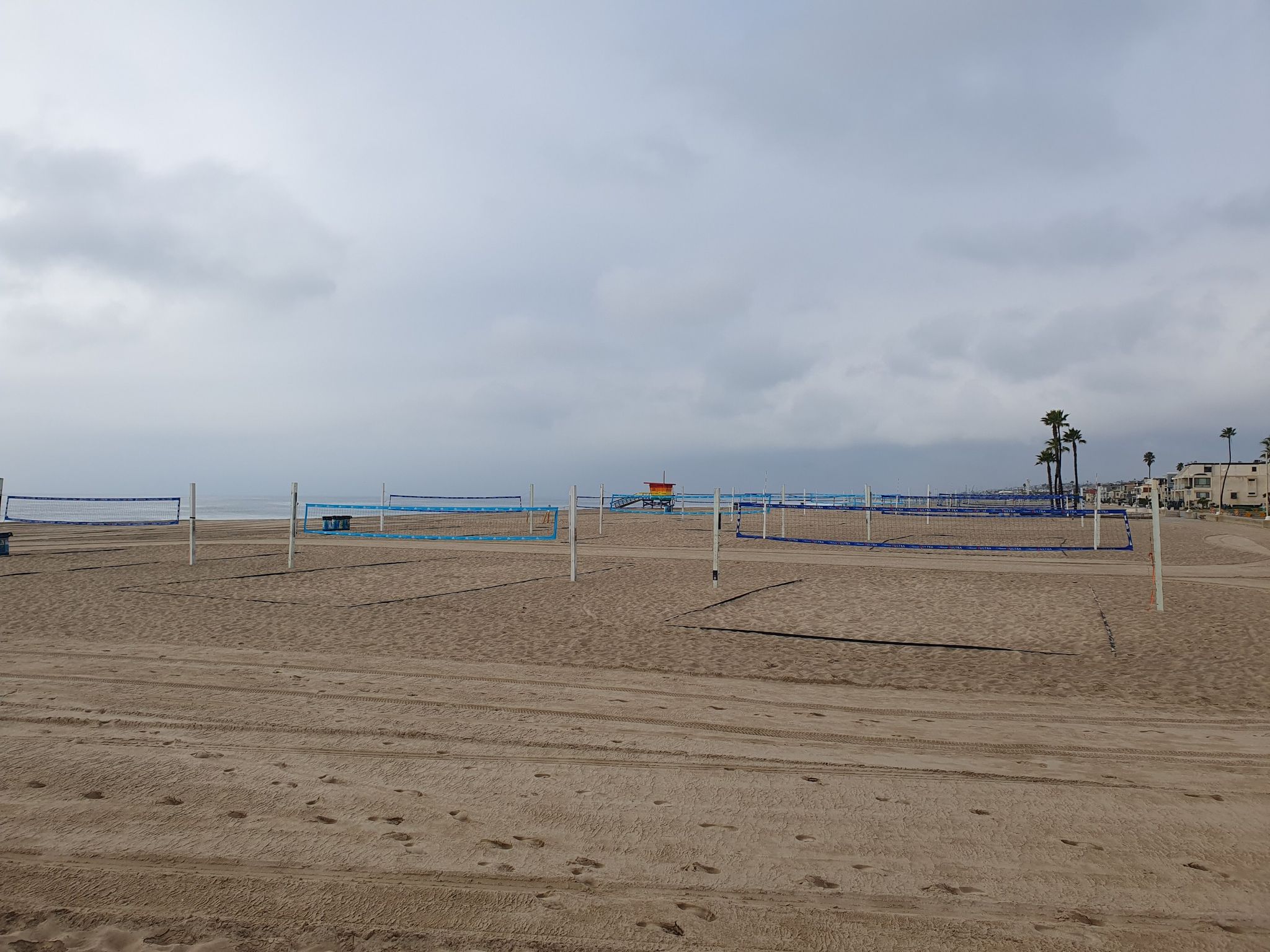 Empty volleyball courts on a wide sandy beach under an overcast sky. - Noble Park – Hermosa City Beach loop from Redondo Beach