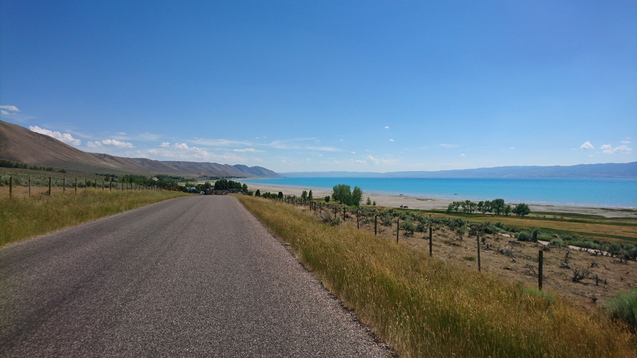 Paved road runs alongside a turquoise lake with hills and mountains. - North Beach – North Cisco Road loop from Logan Canyon Scenic Bypass