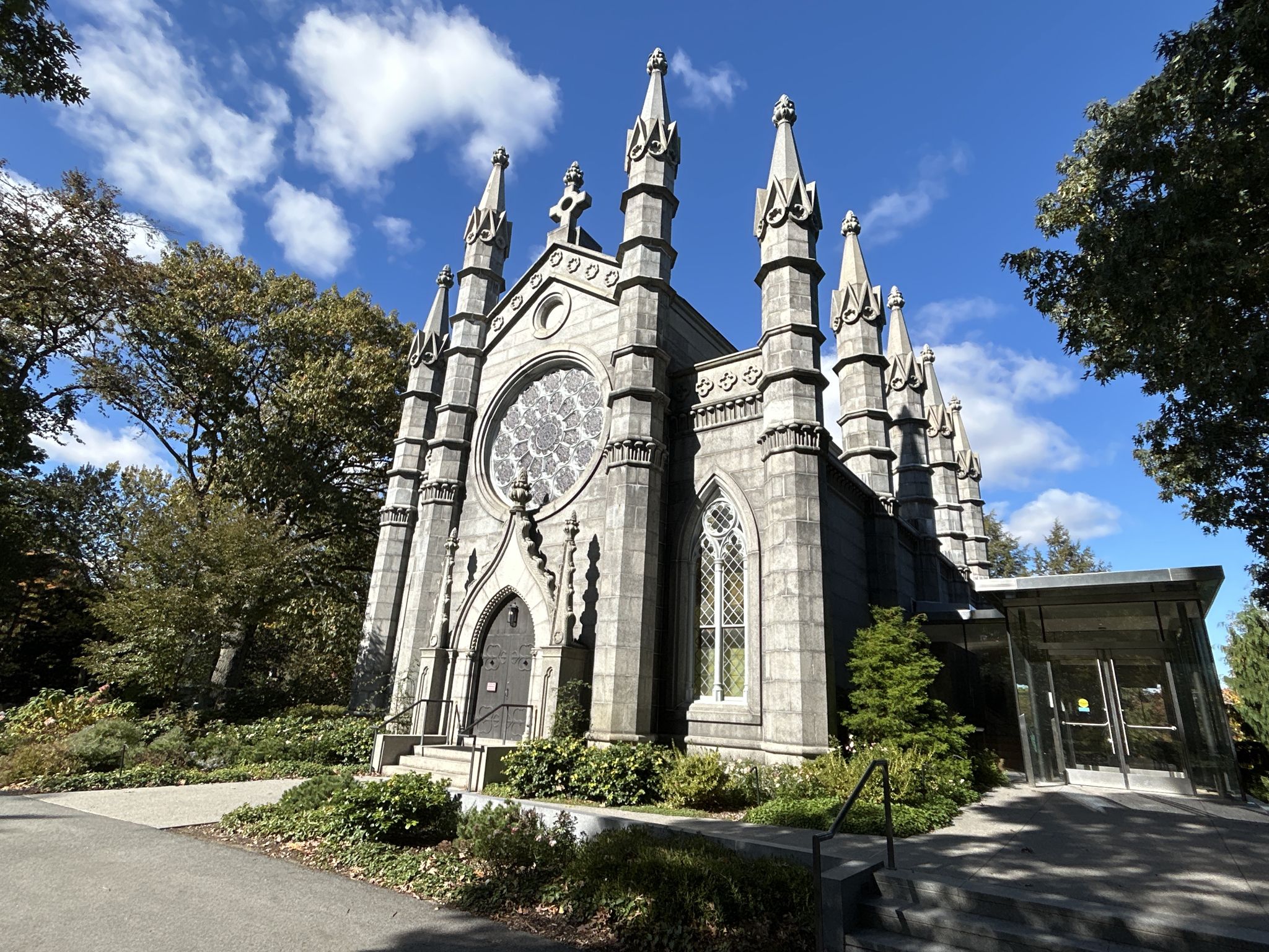 Ornate gothic-style stone building with spires and a large circular window. - Mount Auburn Cemetery Trail