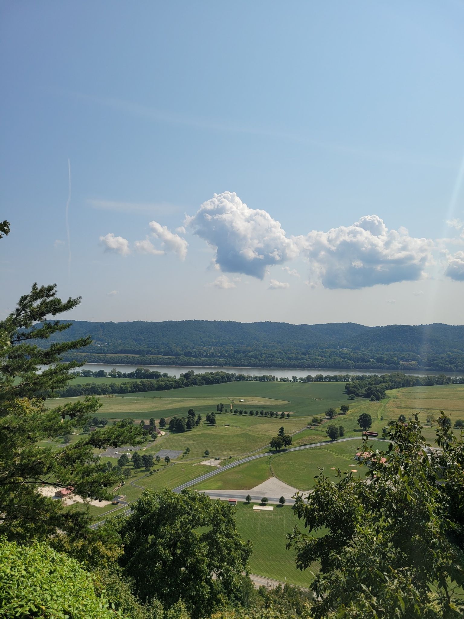 Panoramic view of a wide river valley under a bright, cloudy sky. - Raven Rock Trail