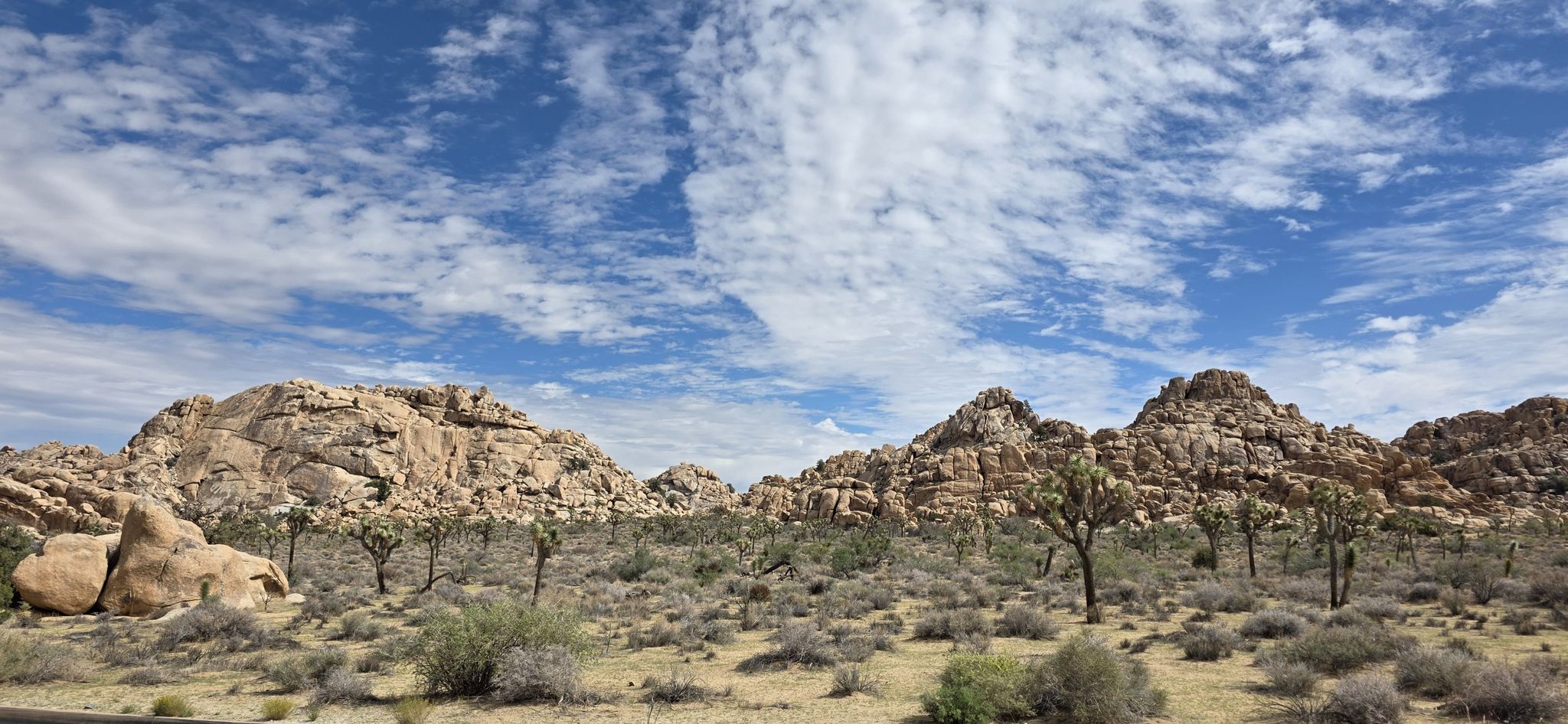 Rocky desert hills under a partly cloudy sky with sparse vegetation. - Joshua Tree National Park Scenic Drive via North Entrance
