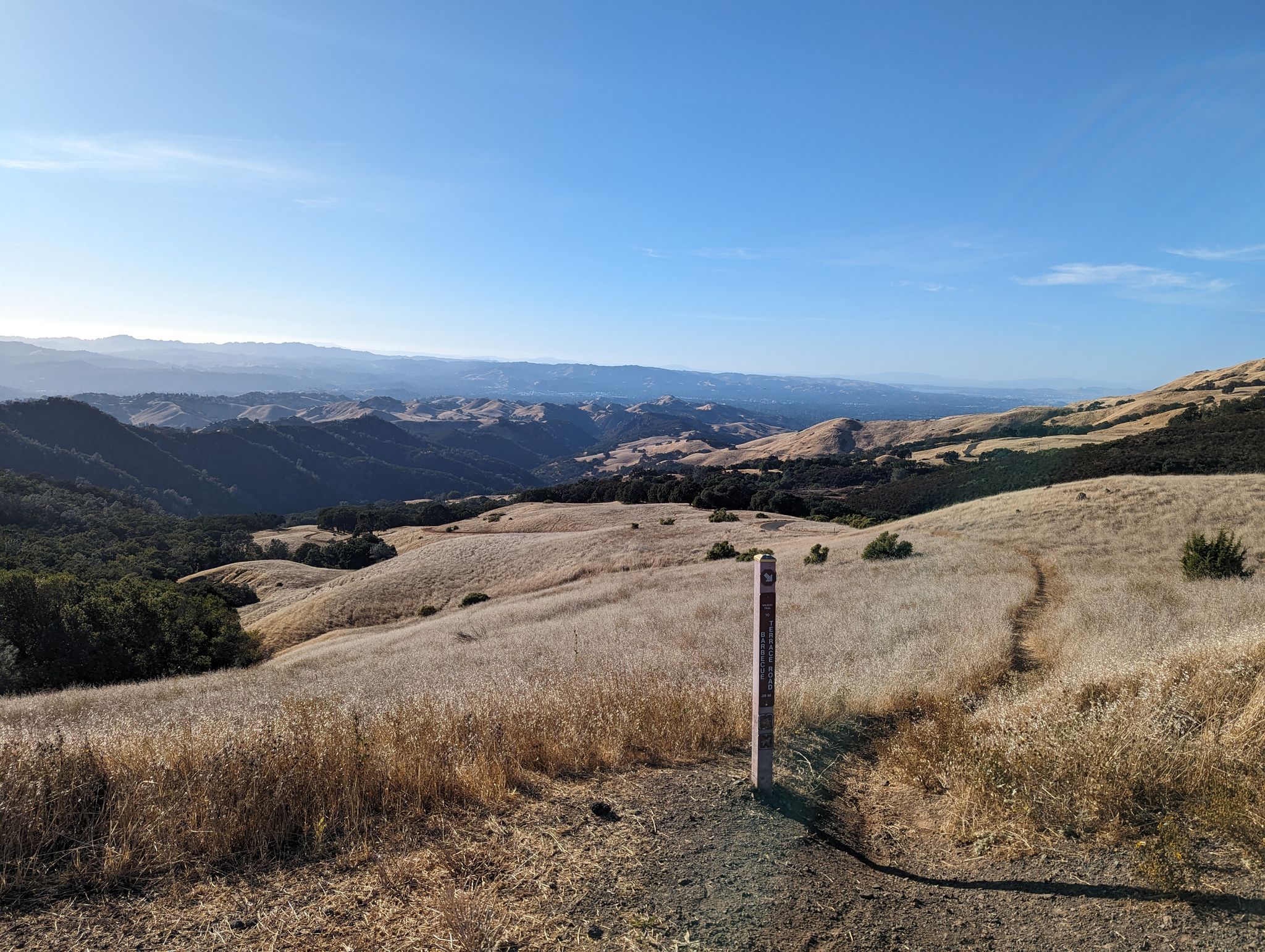A trail marker stands on a path through golden hills under a clear sky. - Diablo Summit Long Loop: Stage, Burma, Summit, and Wall Point