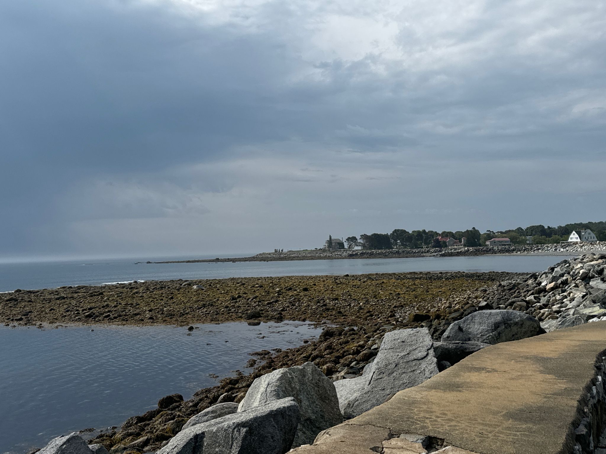 A rocky coastline and ocean under a dramatic, cloudy sky. - East Coast Greenway: New Hampshire Coast
