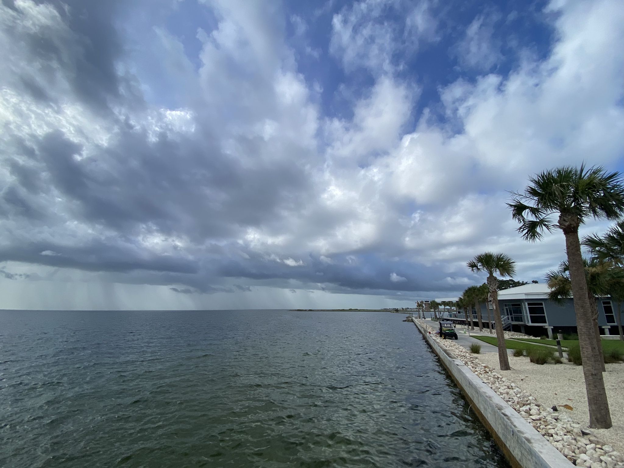 Wide body of water under dramatic cloudy sky, with distant shoreline. - St. Pete Pier – Pinellas Trail loop from West and East Lealman