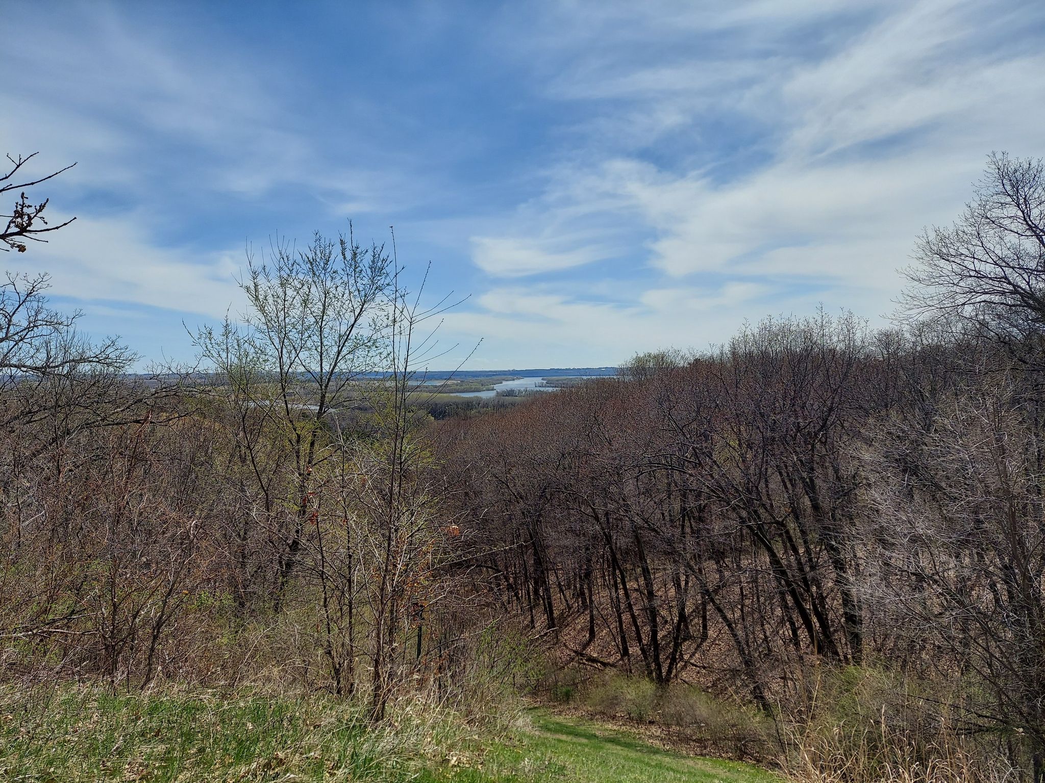 Overlook of a wide valley and distant river under a partly cloudy sky. - Pine Bend Bluff SNA – View of the Mississippi River loop from Inver Grove Heights