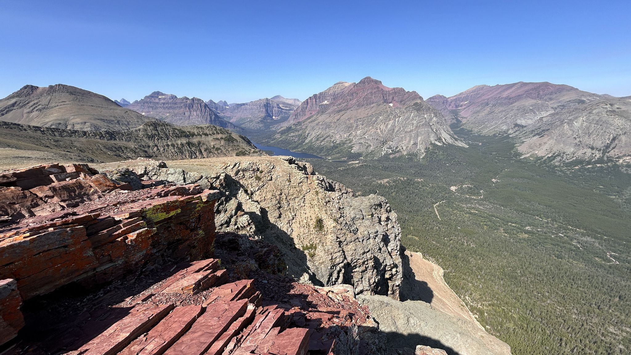 Panoramic view of rugged mountains, a valley lake, and clear blue sky. - Mount Henry Trail and Scenic Point via East Glacier Park Village