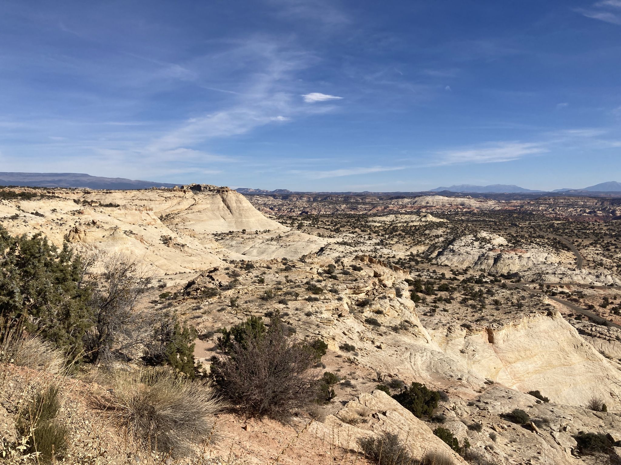 Vast desert landscape with white rock formations under a bright blue sky. - Boulder to Escalante Cycle Route