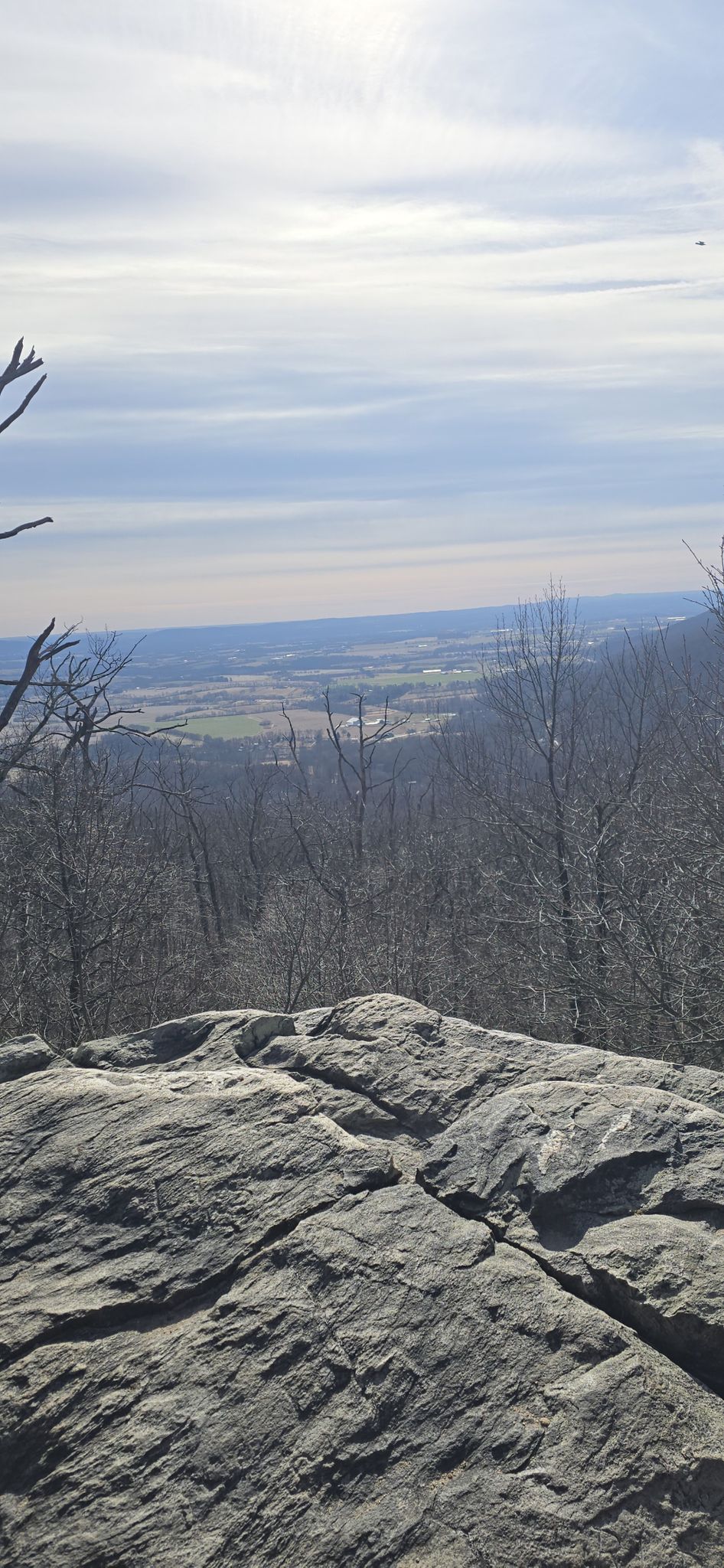 Rocky outcrop overlooks a valley with bare trees under a bright, cloudy sky. - Appalachian Trail to Lambs Knoll and White Rocks