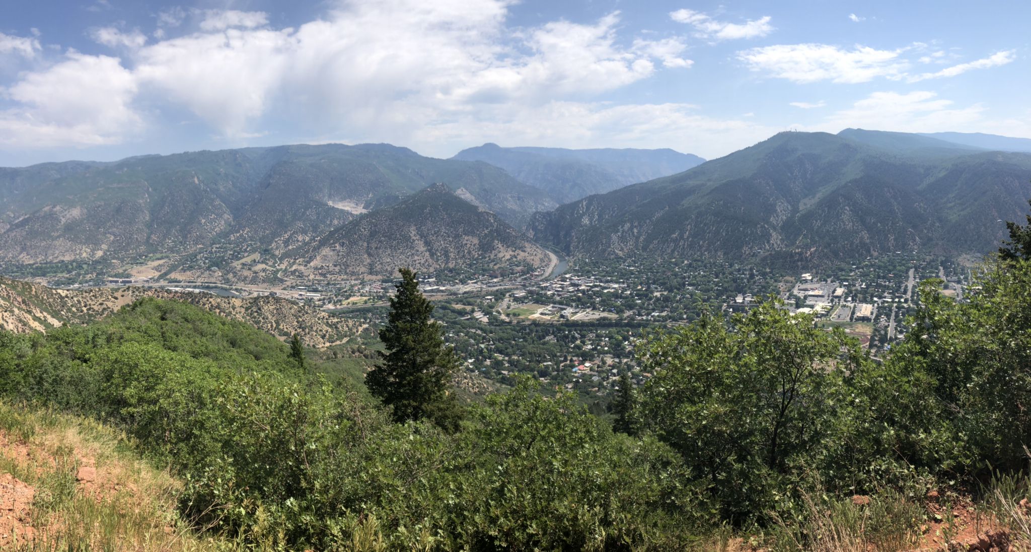 Panoramic view of a town in a mountain valley under a cloudy sky. - View of Roaring Fork River – Red Mountain loop from Sopris Elementary School