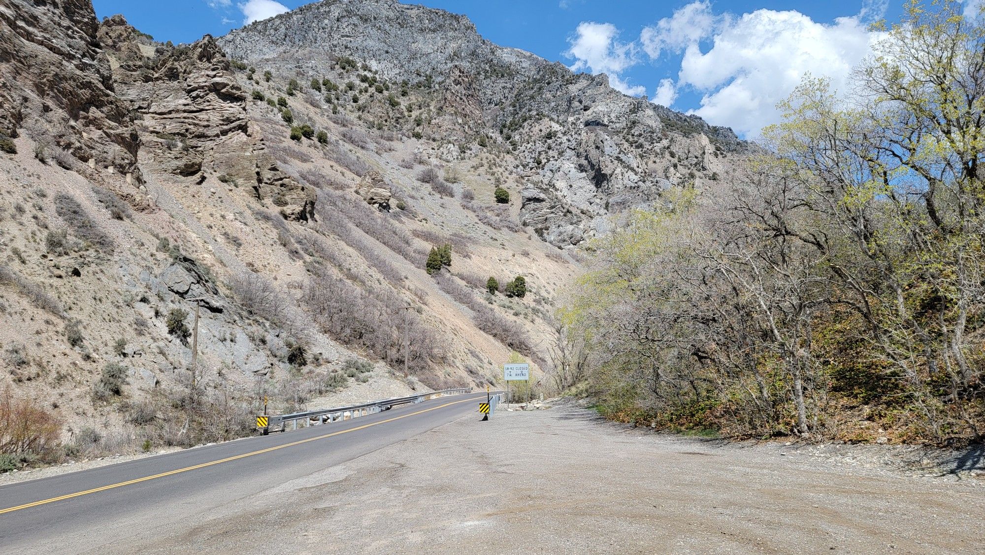 Paved road winding through a steep, rocky mountain canyon on a sunny day. - Utah Alpine loop via Provo River Parkway