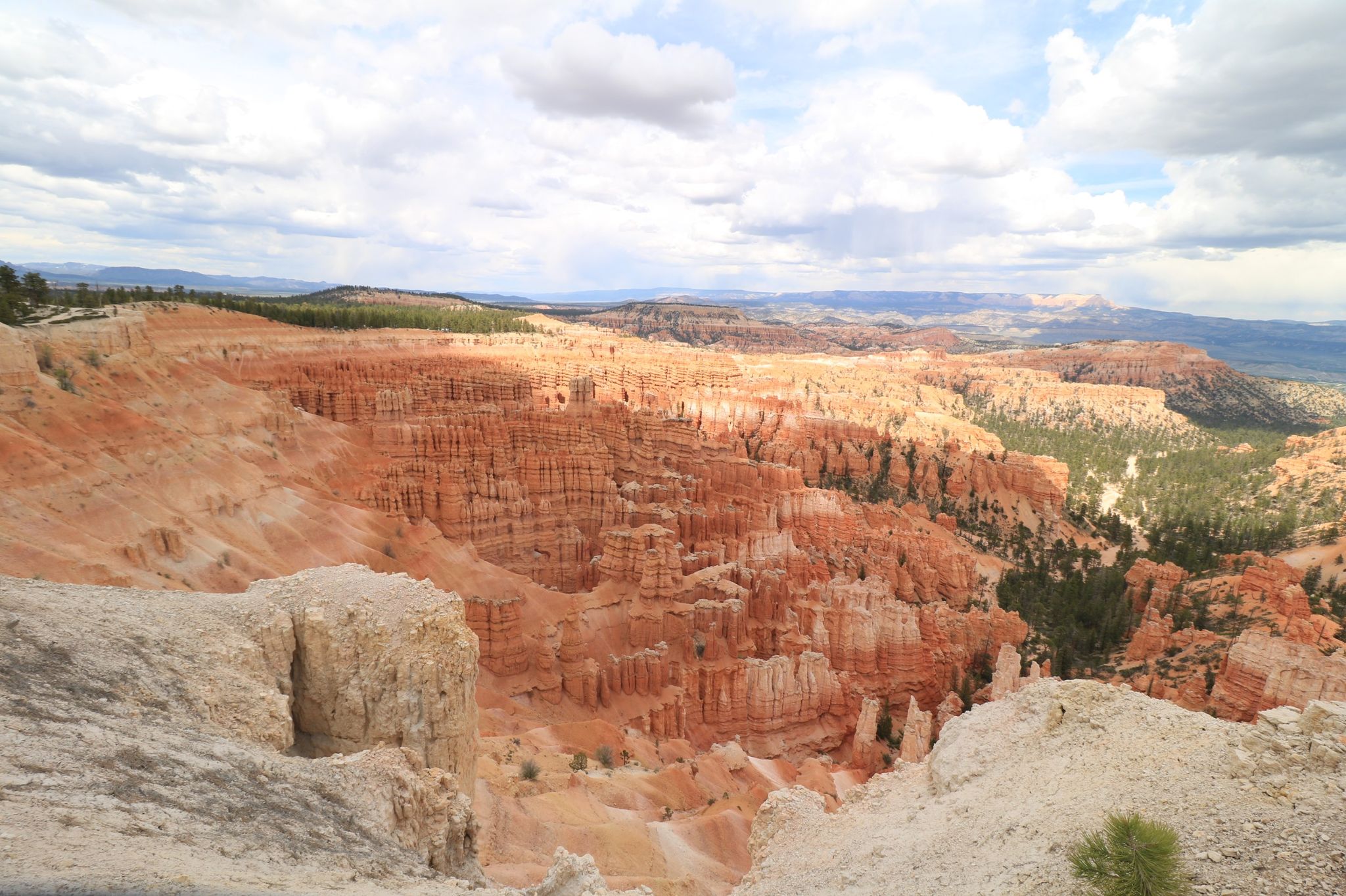 Vast canyon landscape with orange rock formations under a bright, cloudy sky. - Lower Inspiration Point loop from Bryce Canyon Lodge