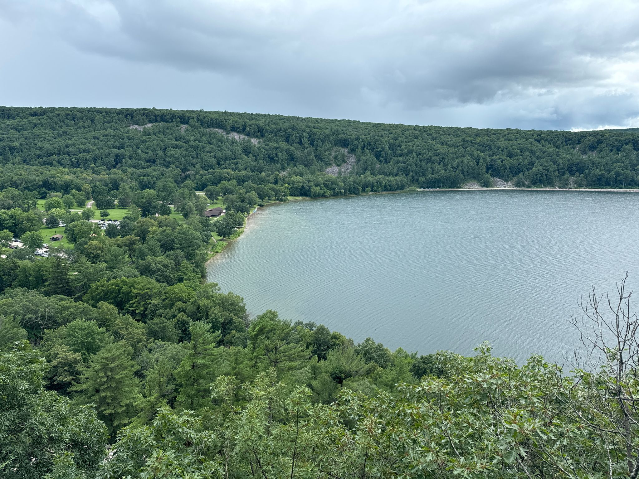 Overcast view of a lake surrounded by dense green forest. - Balanced Rock and Devil's Doorway Loop
