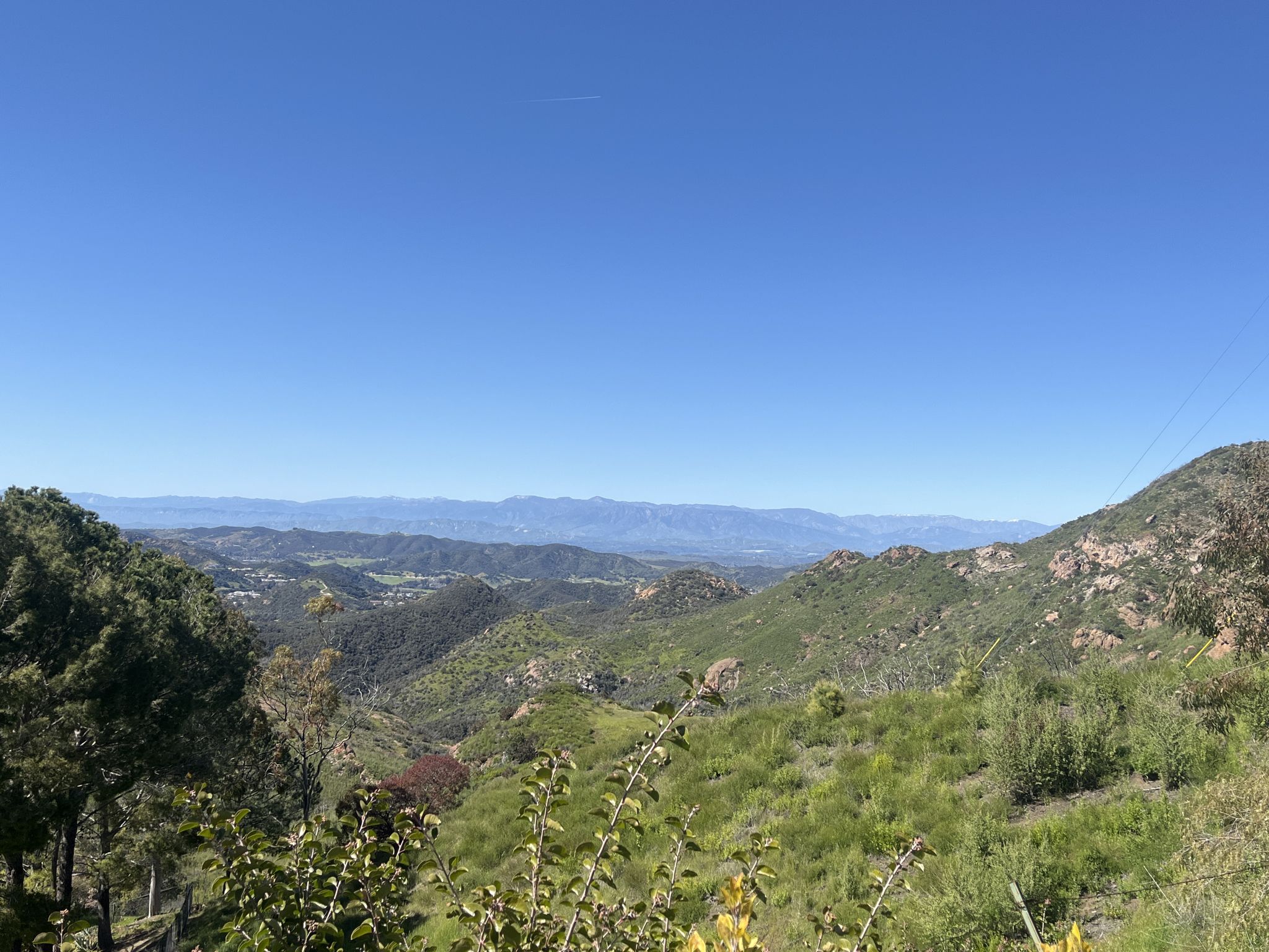 Expansive view of green rolling hills and distant mountains under a clear sky. - Leo Carillo State Park – South Beach loop from Leo Carrillo State Park