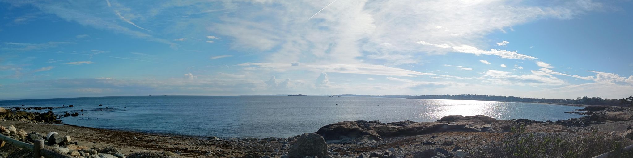 Panoramic ocean view with calm water, rocky shore, and bright sunny sky. - Marblehead Neck loop from Devereux Beach