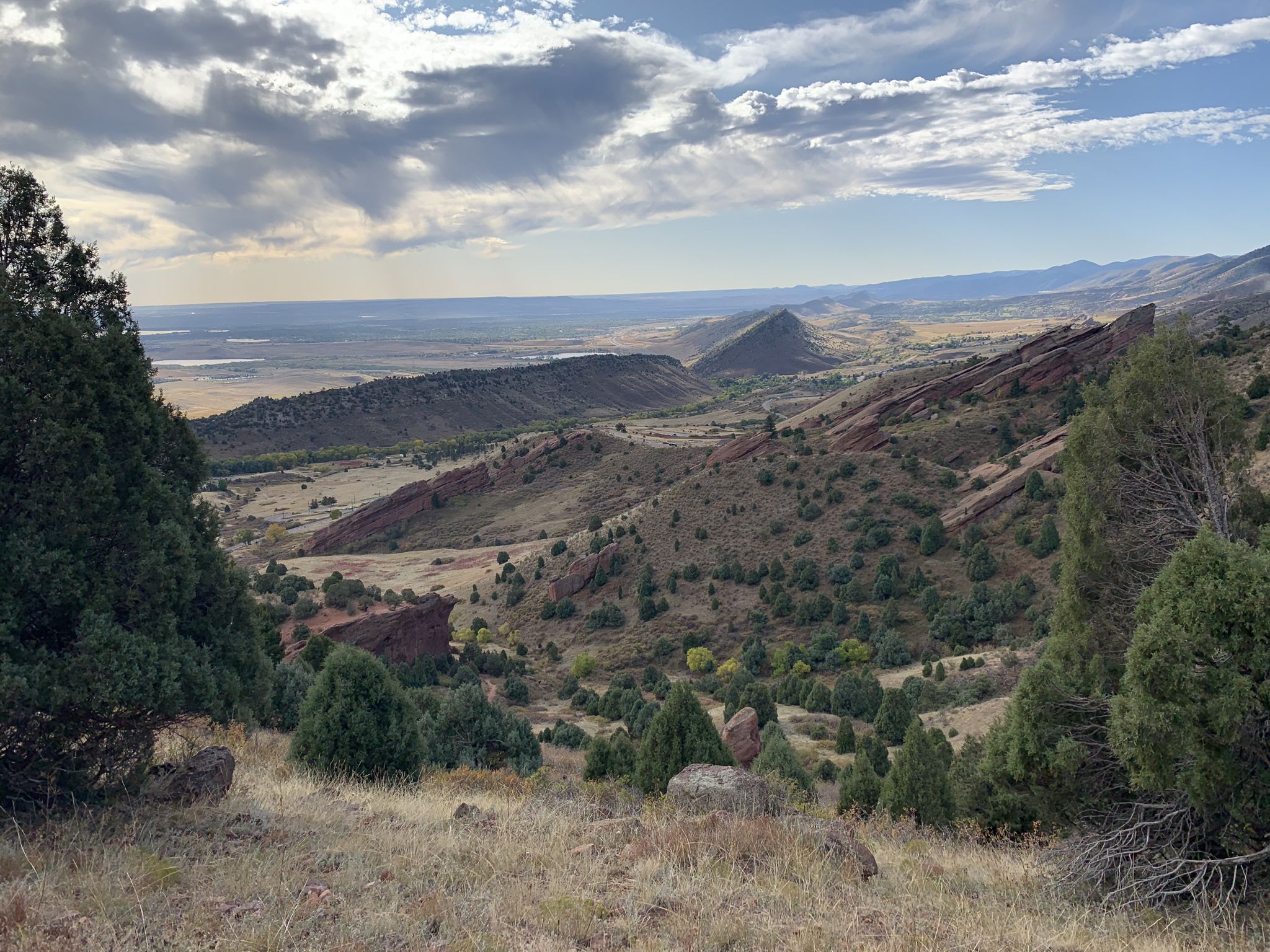 Wide landscape view of rocky hills and distant plains under cloudy sky. - Red Rocks and Morrison Slide Trail Loop