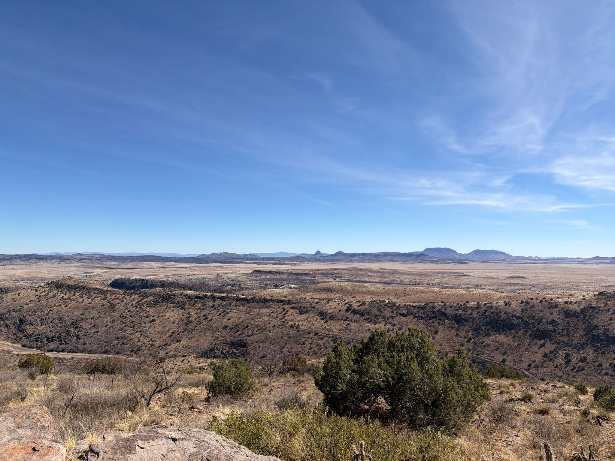 Expansive desert vista with a wide plain, sparse vegetation, and distant mountains. - Limpia Creek Vista loop from Davis Mountains State Park