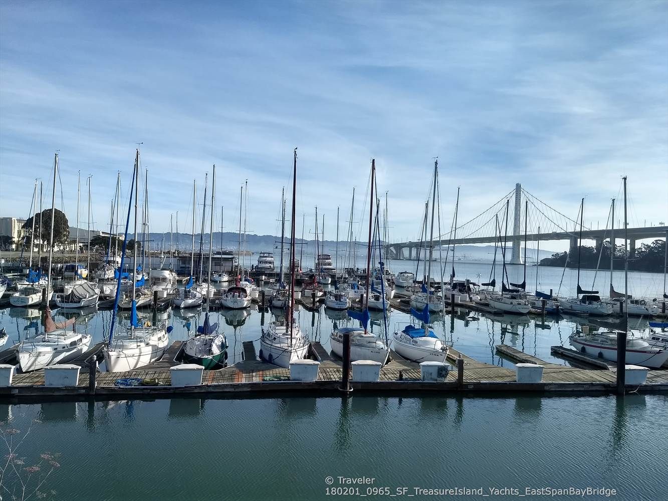 Marina filled with sailboats, with a large suspension bridge in the background. Bright day. - San Francisco Bay Trail to Treasure Island