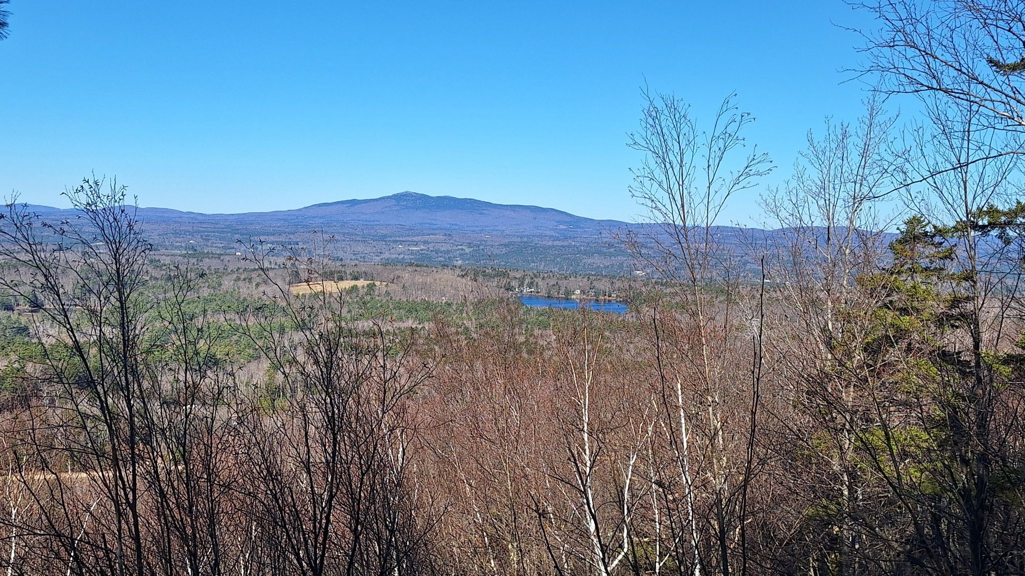 Wide mountain vista with a distant lake under a clear blue sky. - Wapack Trail to Pack Monadnock