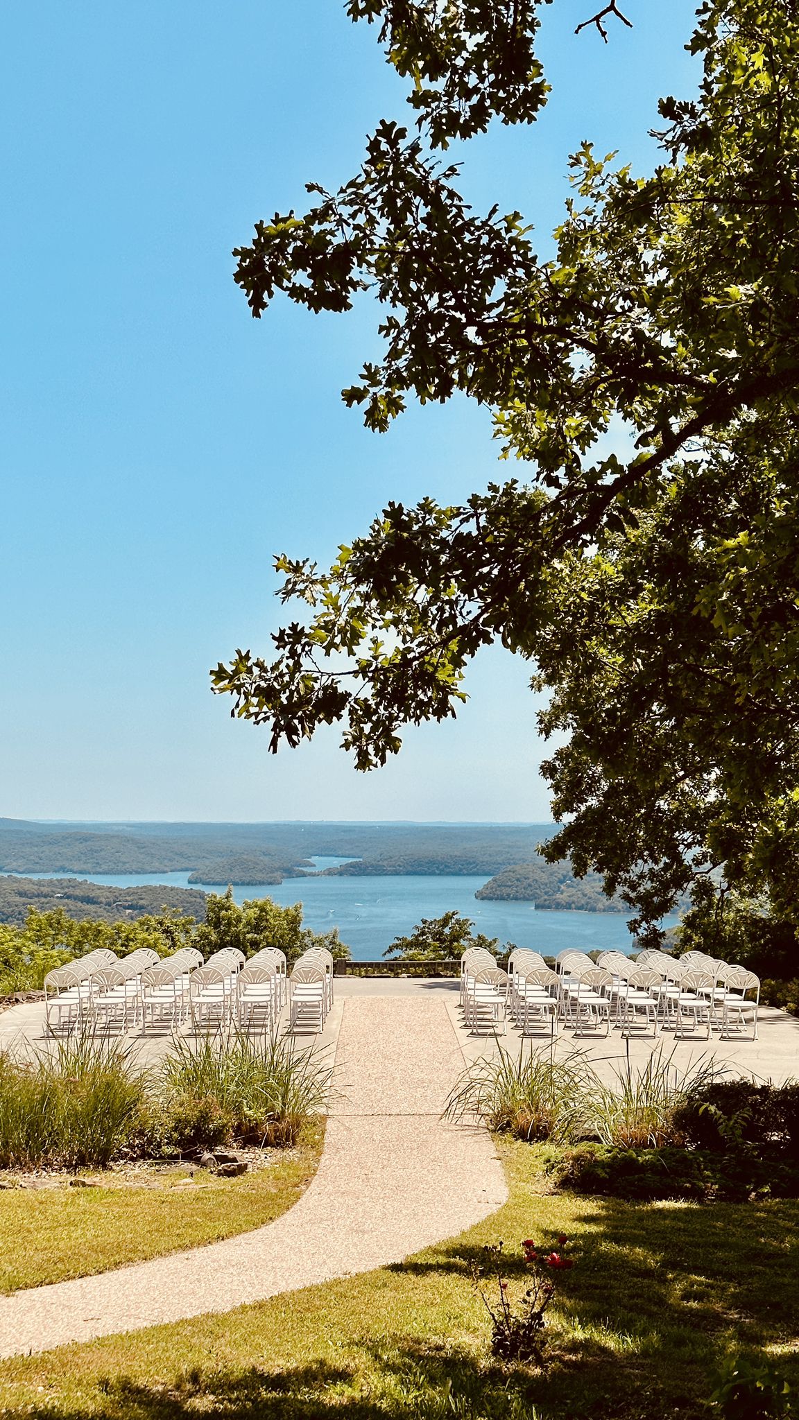 Outdoor event seating overlooking a vast lake and distant hills on a sunny day. - Lost Bridge Trail