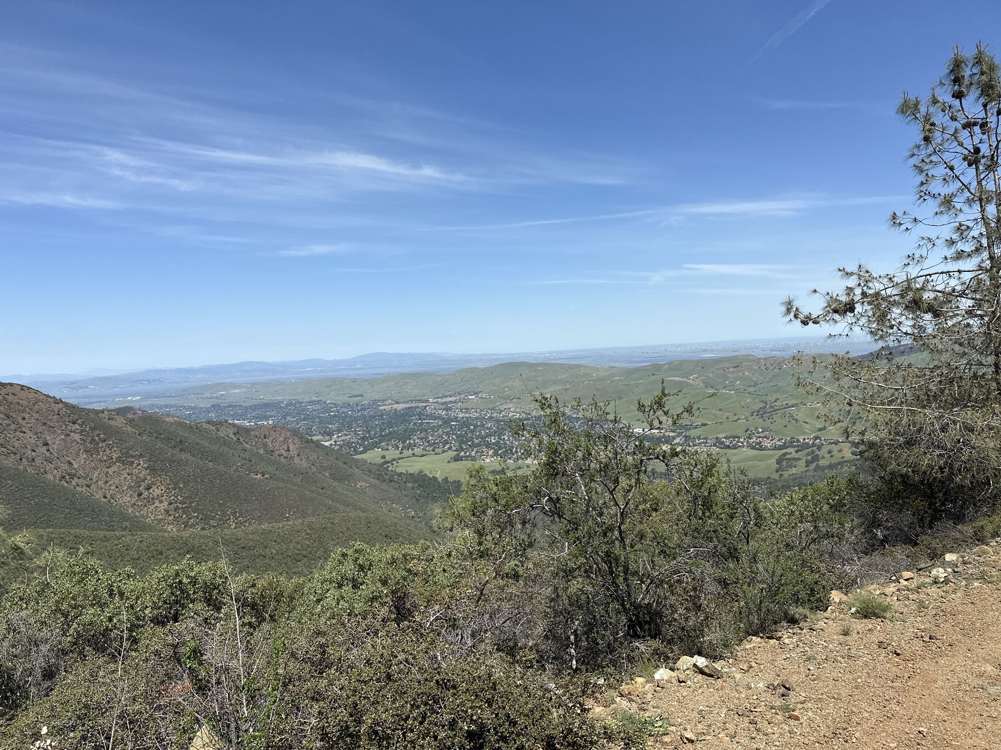 Sunny view of green mountains, a valley, and distant town under blue sky. - Back Creek and Donner Canyon Loop