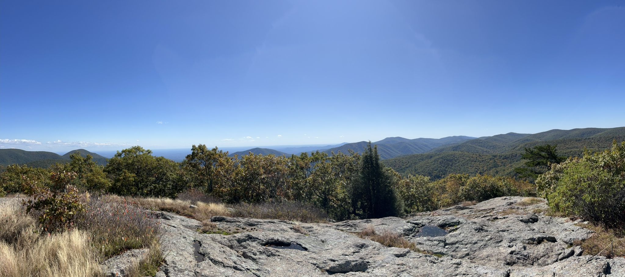 Panoramic view of rolling mountains under a clear blue sky from a rocky outcrop. - Spy Rock Trail via Cash Hollow