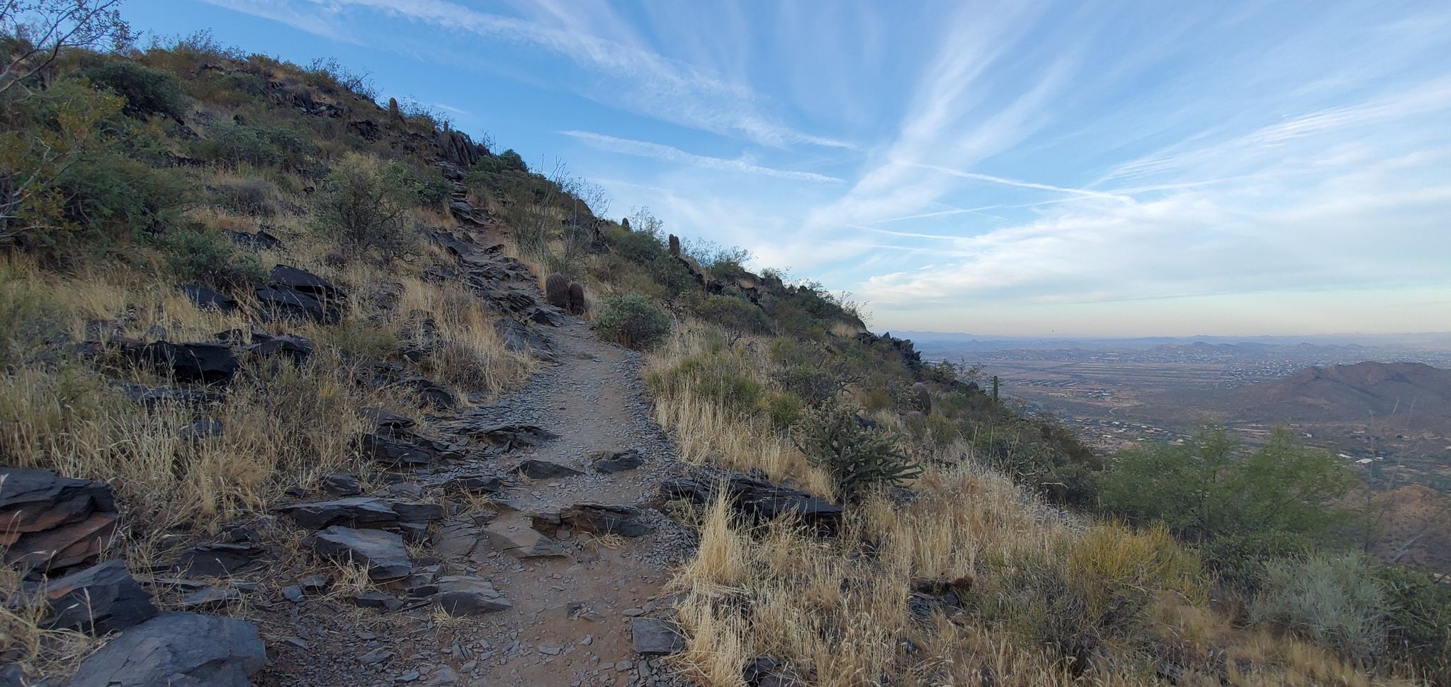 Winding dirt trail on a rocky, arid hillside under a blue sky. - Black Mountain Trail