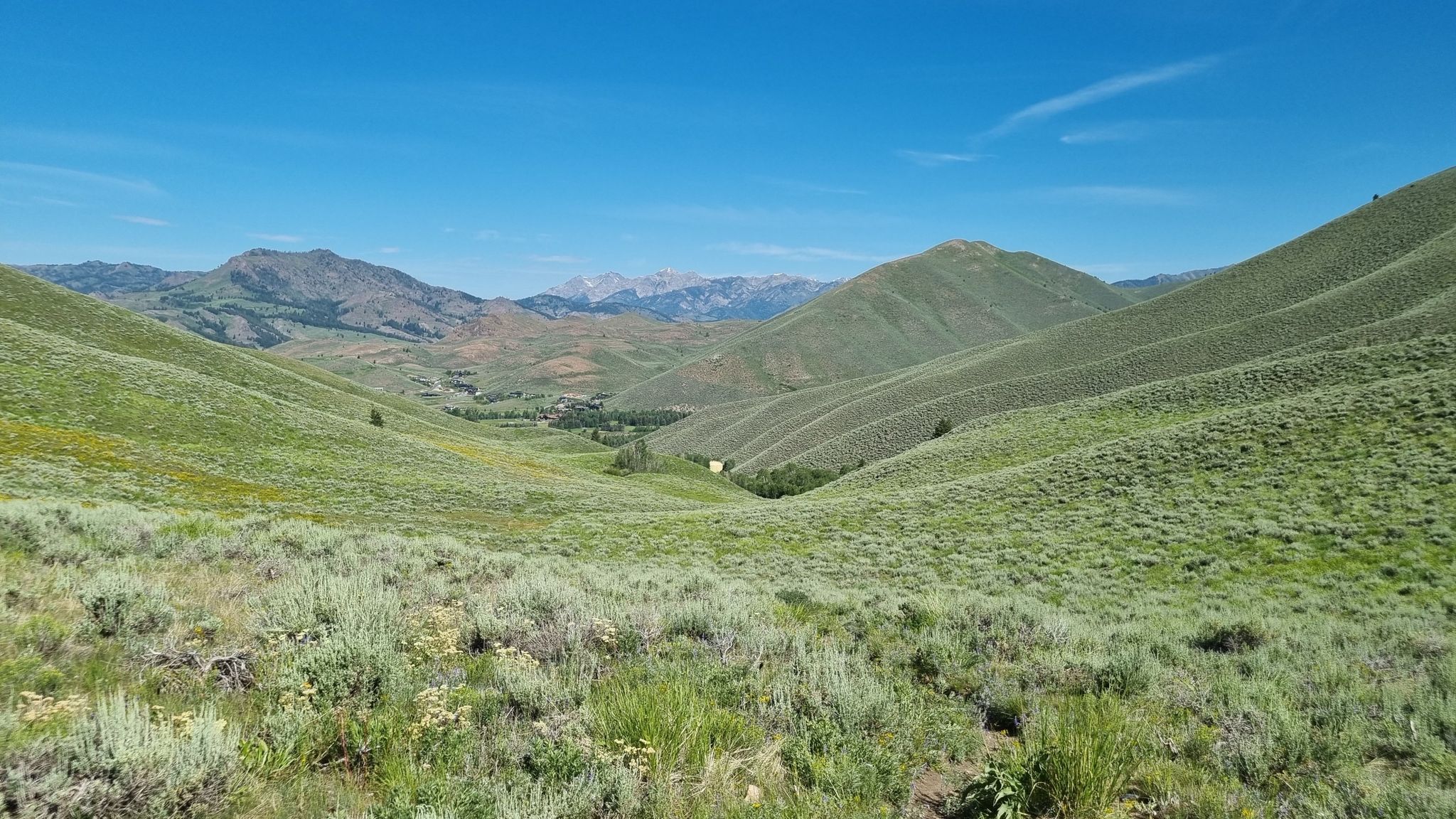 A wide valley with rolling green hills under a bright blue sky. - Prospect Hill Loop
