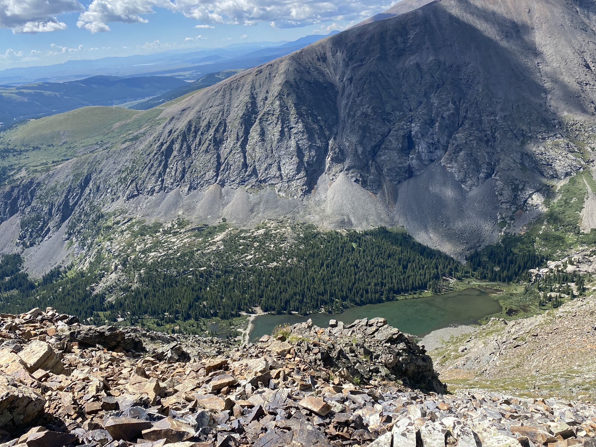 High angle view of a mountain lake surrounded by forest and peaks. - Quandary Peak Trail