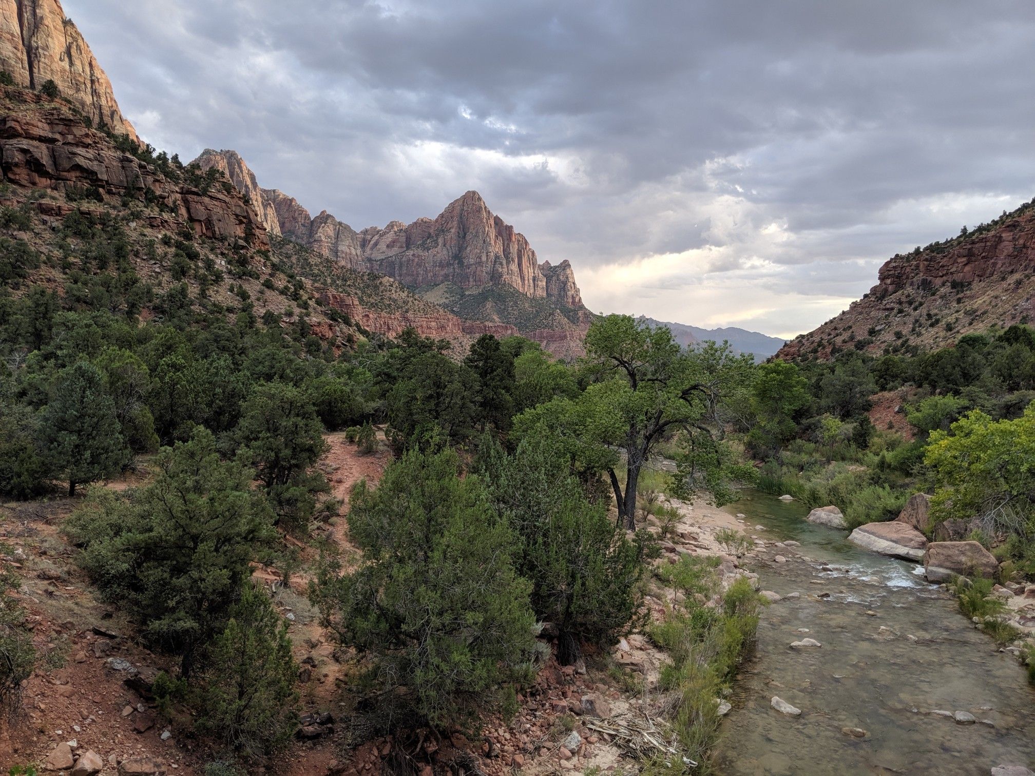 Scenic valley with a river, green trees, and towering rock formations. - Pa'rus Trail and Zion-Mount Carmel Highway