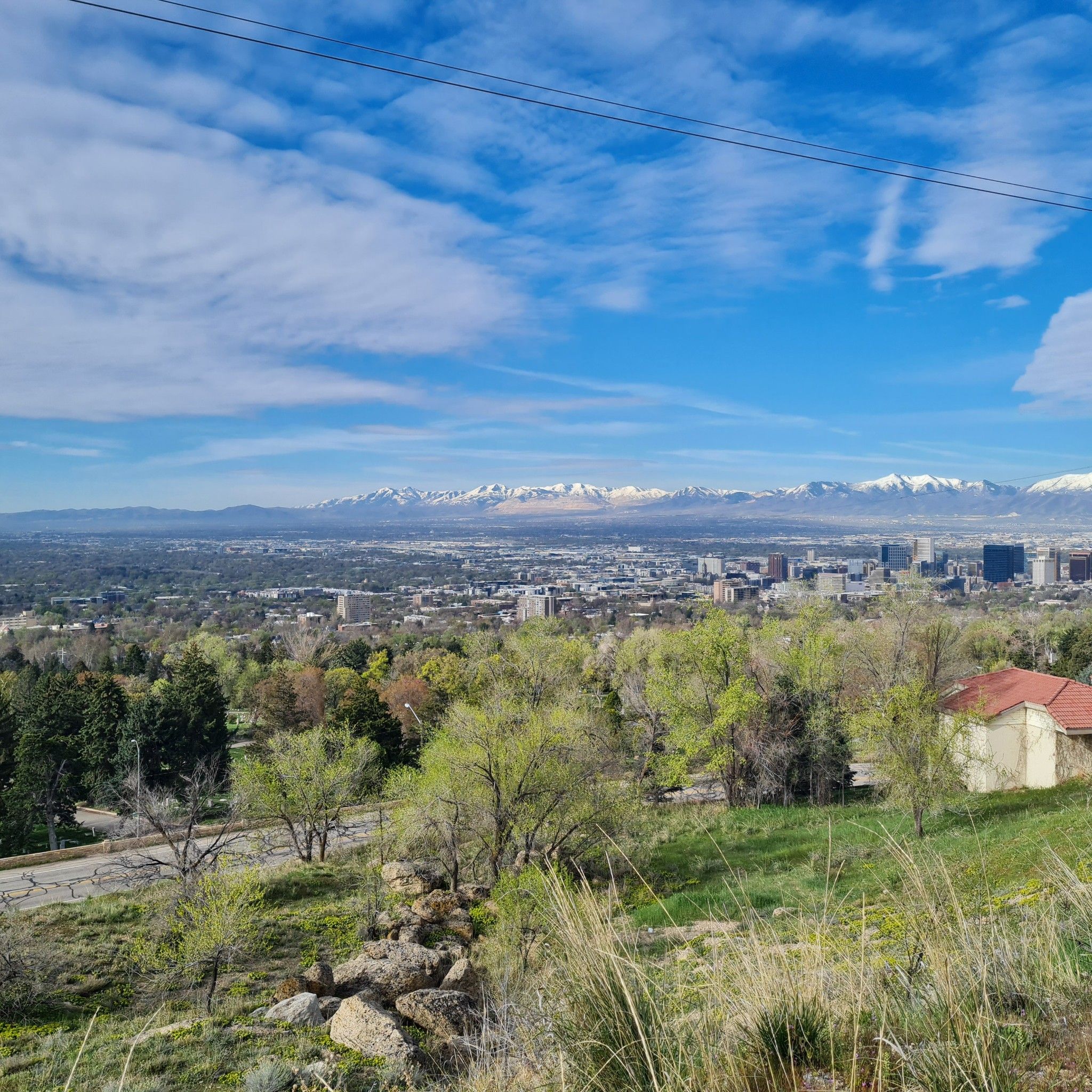 Bright view of a city in a valley with distant snow-capped mountains. - Bonneville Shoreline Trail, Dry Creek, and Bobsled Loop