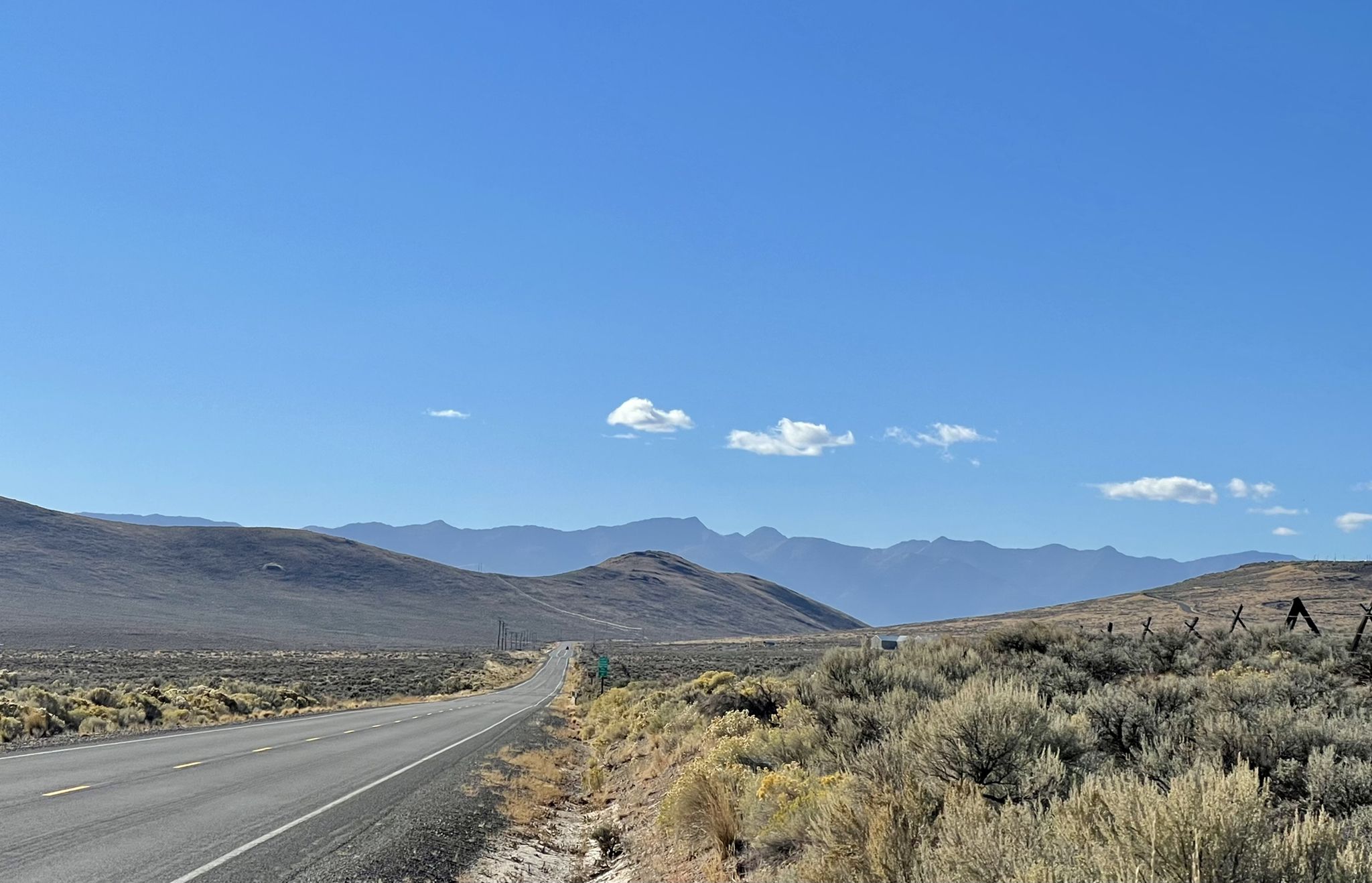 Long desert road stretches towards distant mountains under a clear blue sky. - Keating Valley loop
