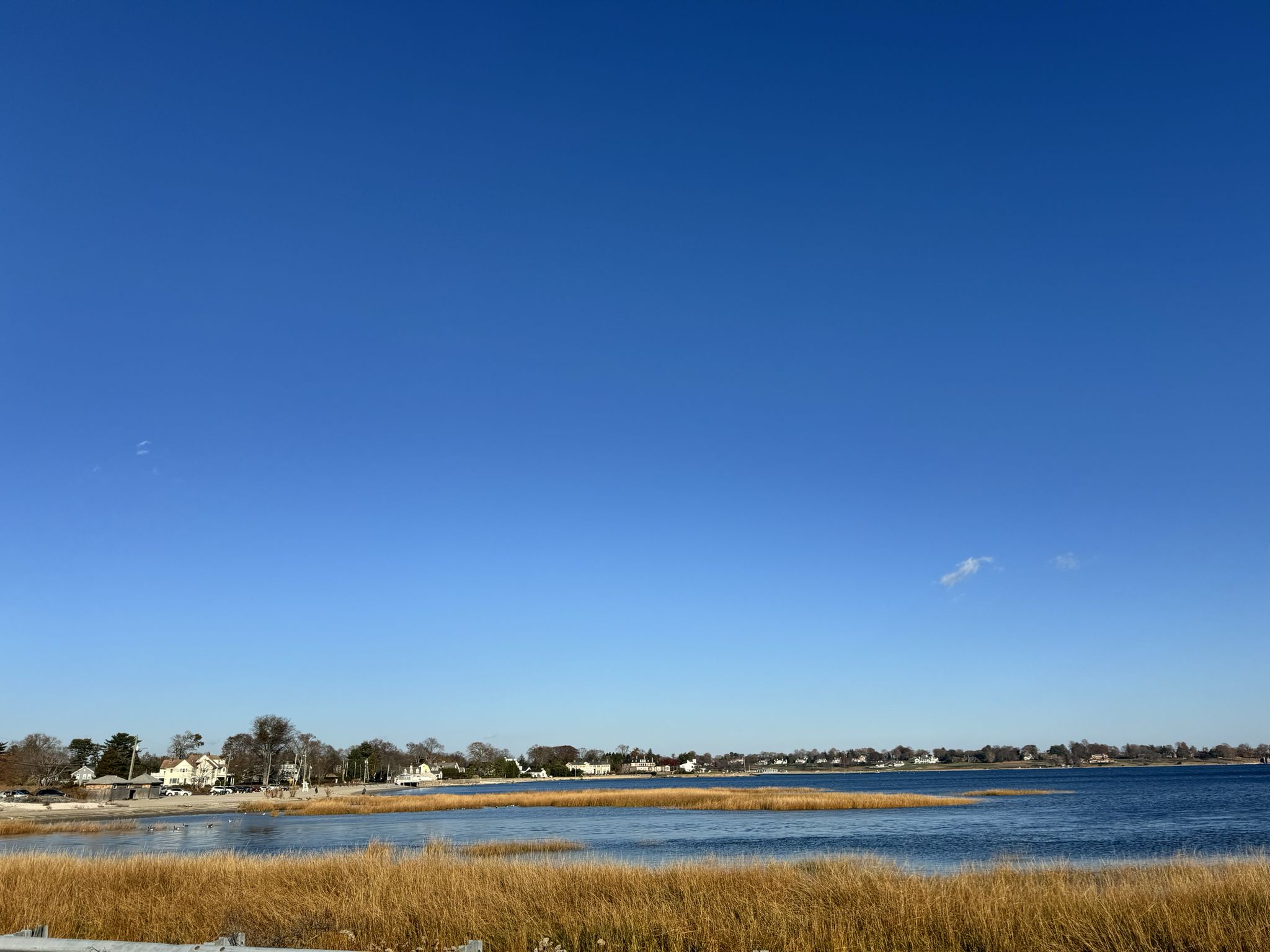 Clear blue sky over calm water, golden marsh grass, and distant houses. - Harbor Road - quiet and pretty neighborhood – Pequot Avenue (brand new surface) loop from East Norwalk
